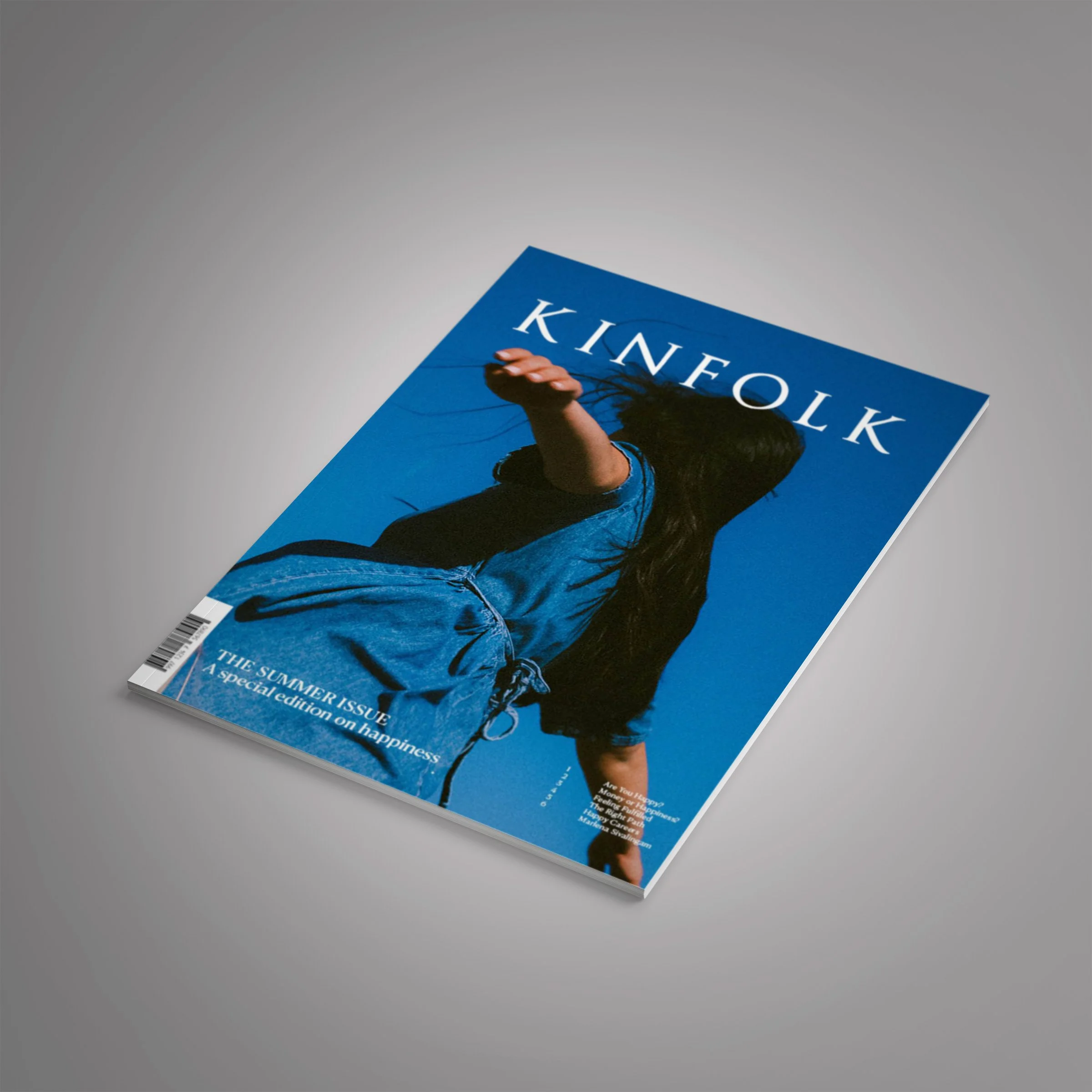 The cover of Kinfolk magazine happiness edition laid on a grey background.