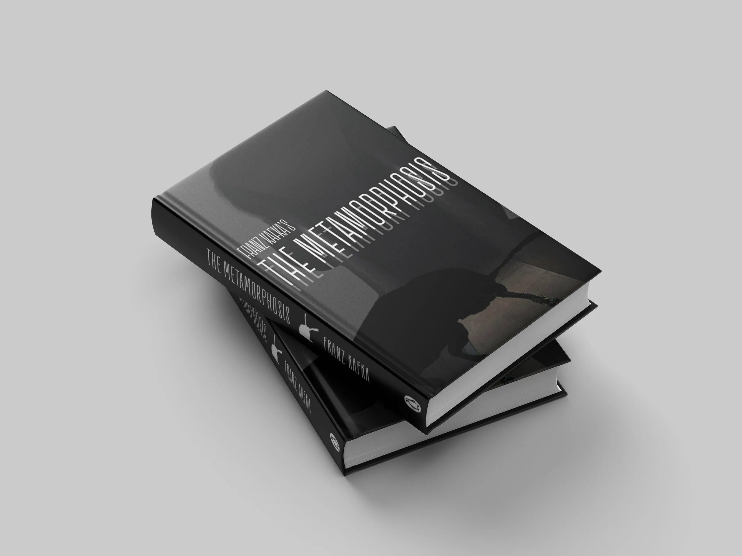 Two books of The Metamorphosis stacked on top of one another on a grey background.
