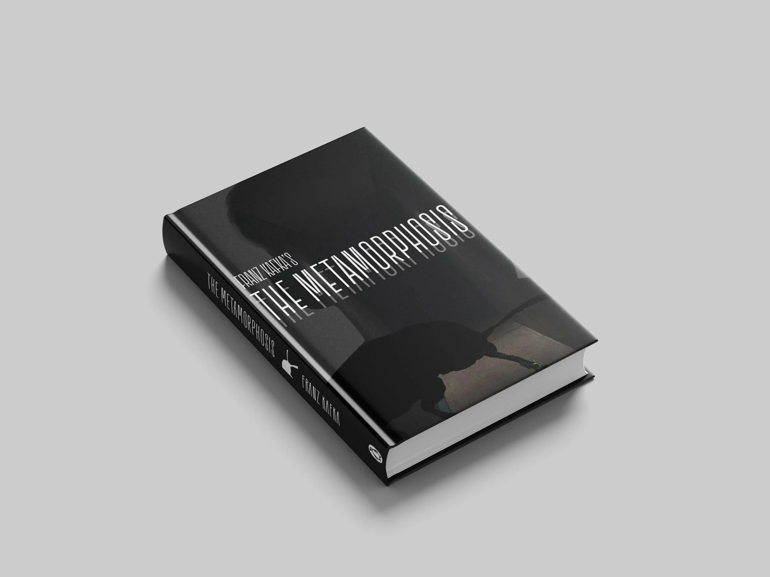 A closed cover of The Metamorphosis book laid on a left angle on a grey background.