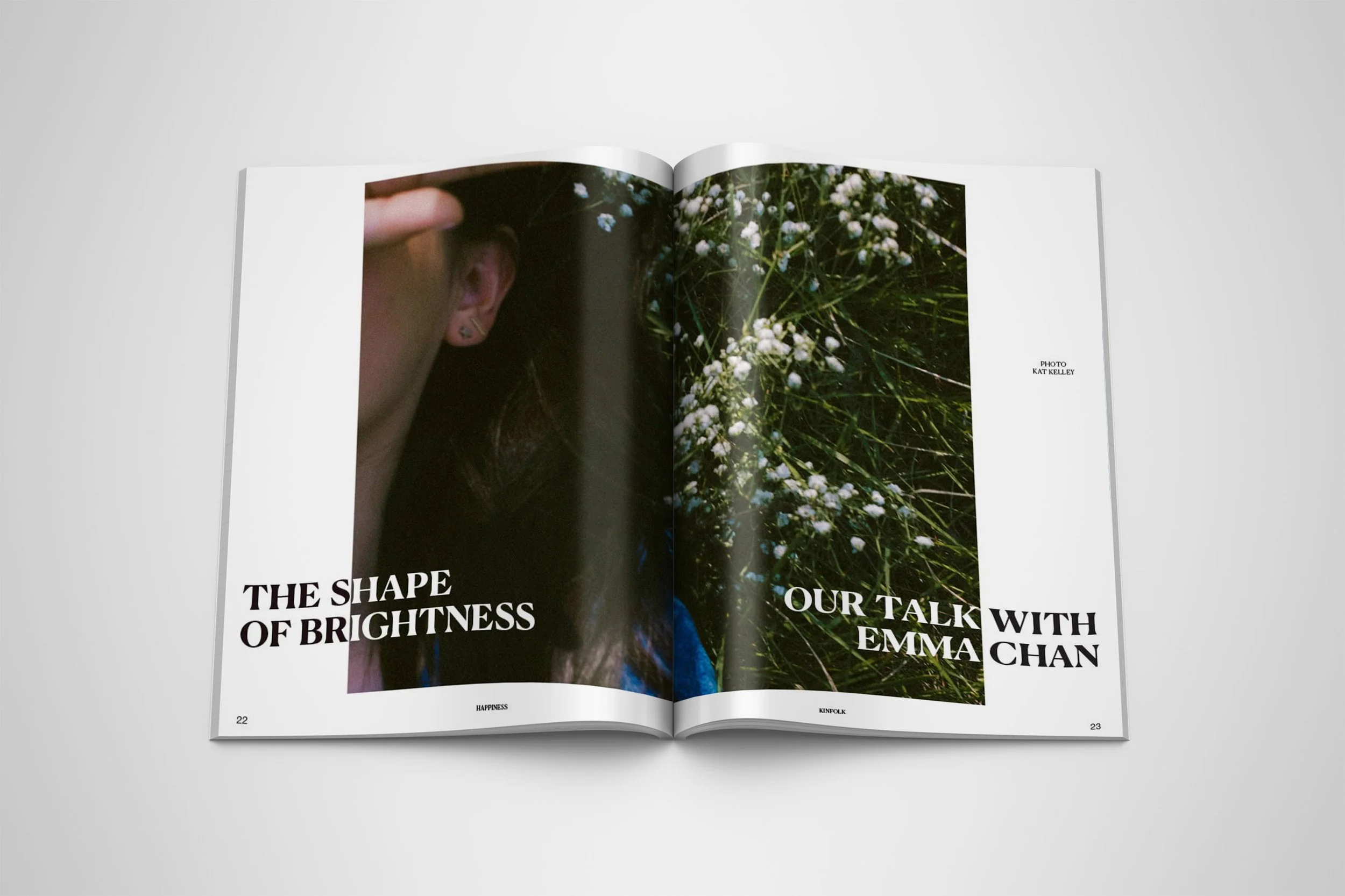 An open Magazine Spred called the shape of brightness our talk with Emma Chan with an close up image of a girl's face covered by her hand laying on grass with small white florals.