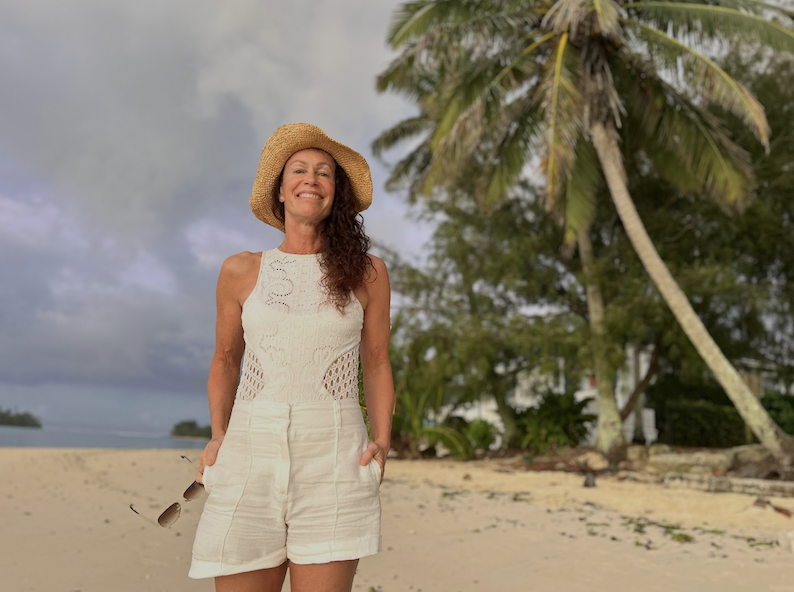 Anandi at one of her overseas yoga retreats in Rarotonga standing on a beach.