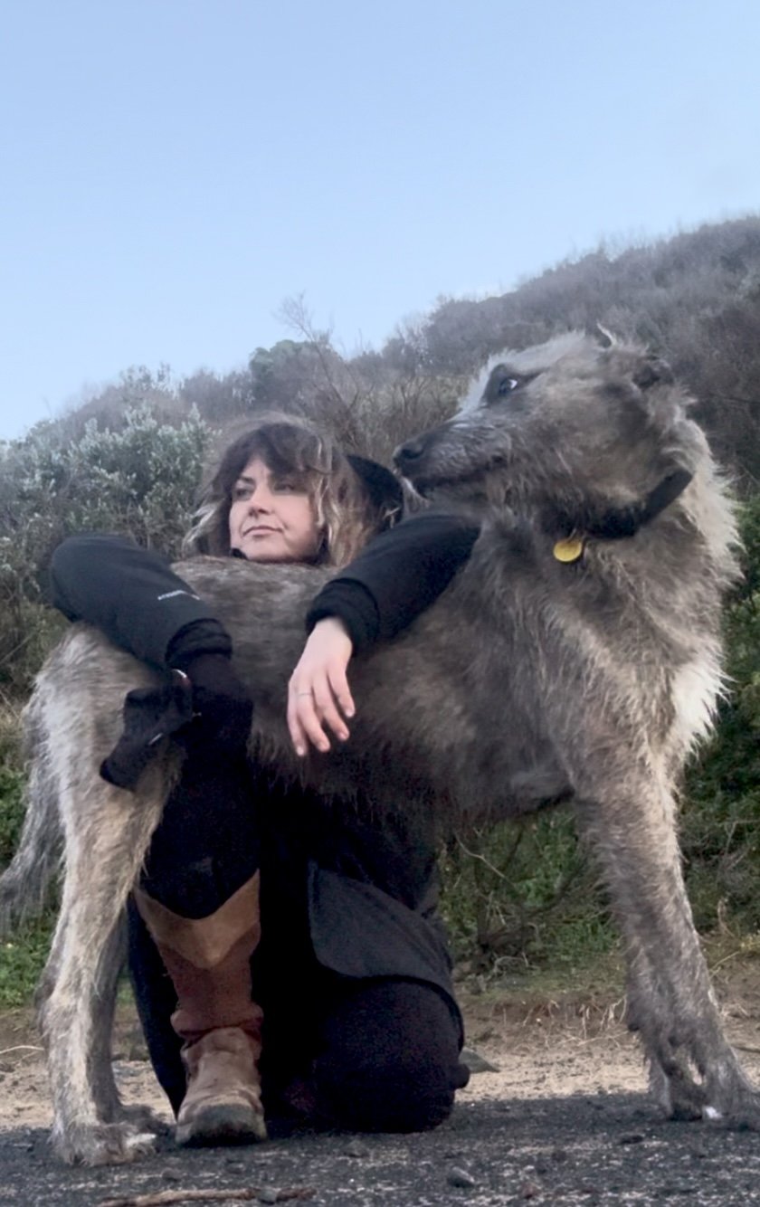 Jo Angwin and her wolfhound Noonah outdoors under big skies. Off grid living in nature.