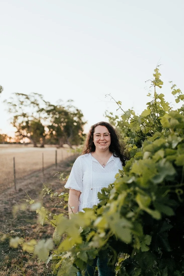 Emily Bryson smiling outdoors in a green vineyard — naturopathic care for women's health South Australia