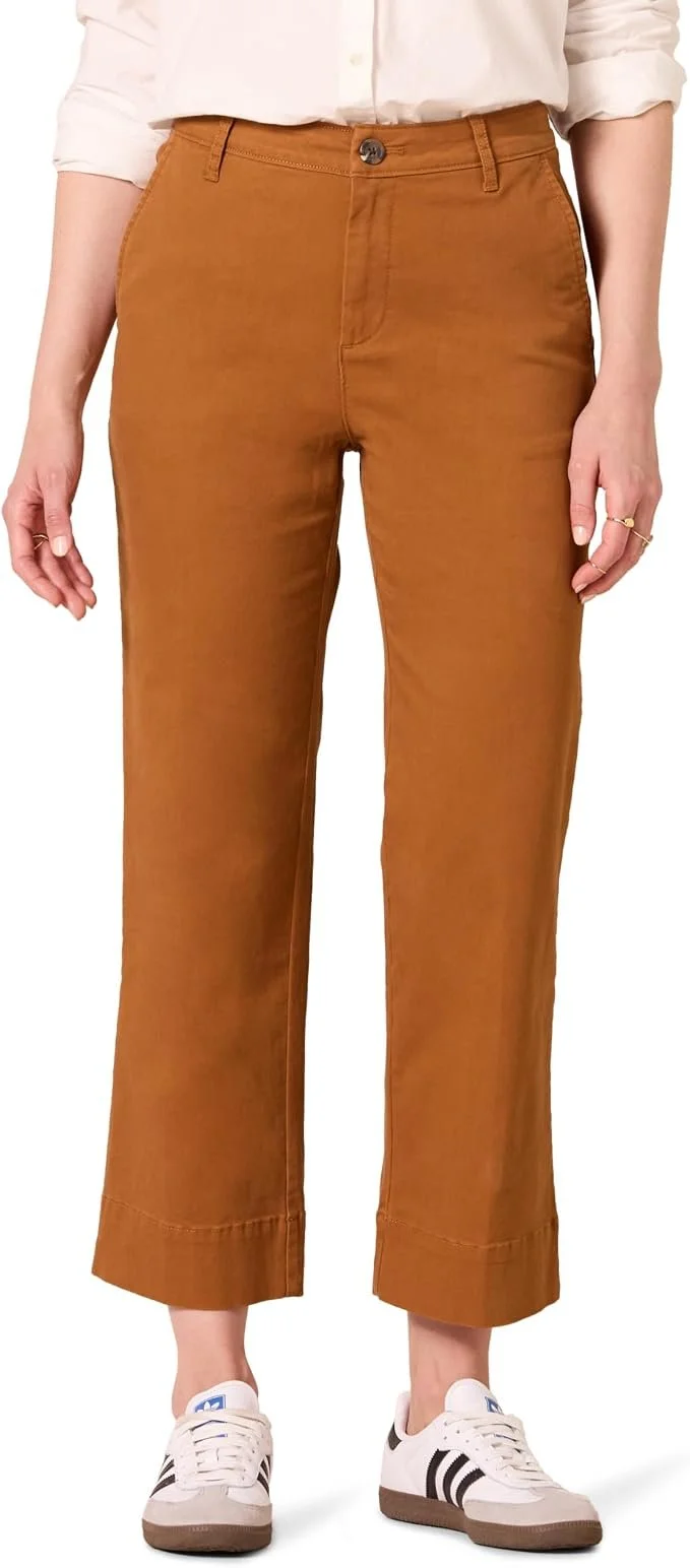 Woman wearing tan wide-leg pants, white sneakers, and a white shirt.