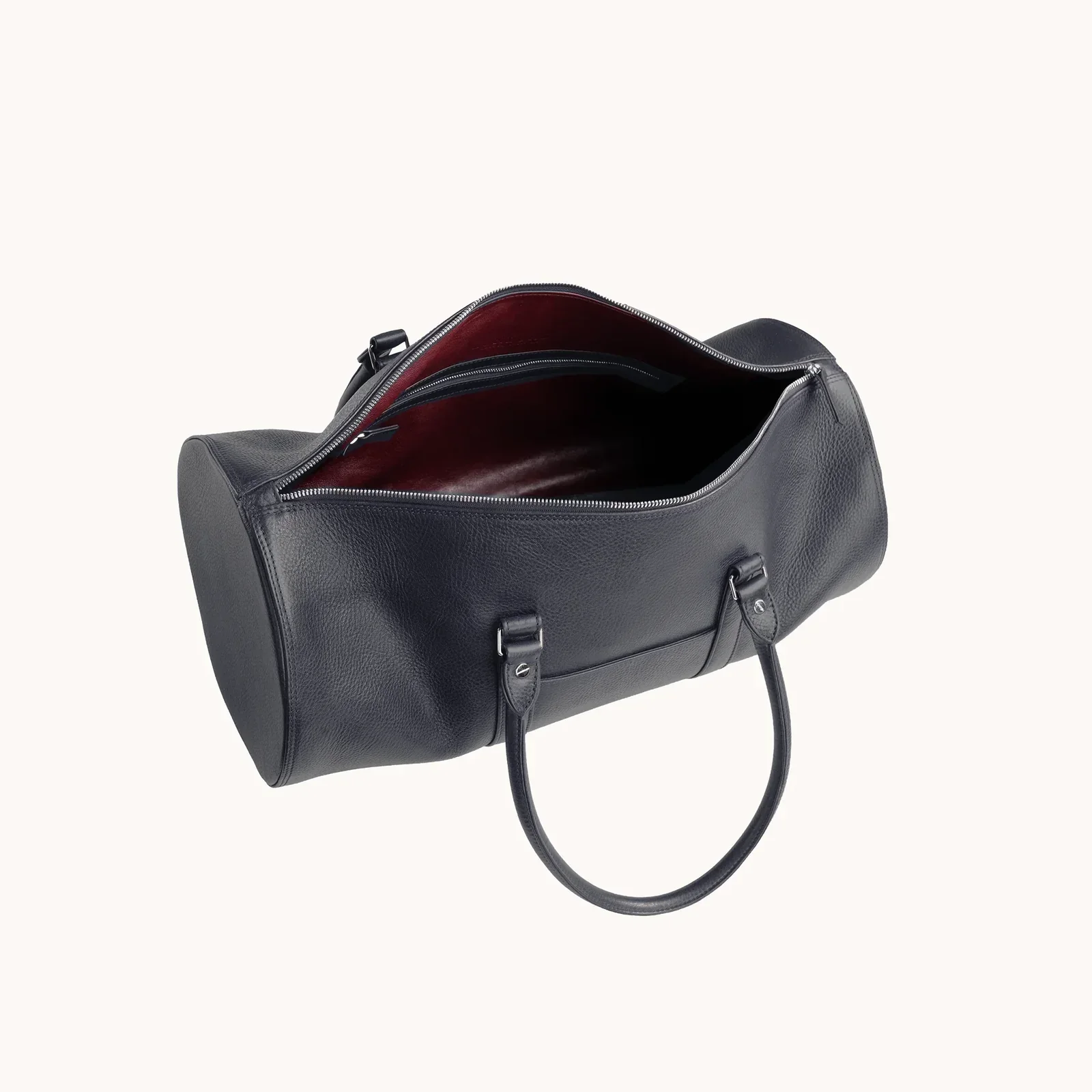 Black leather duffel bag with open zipper showing red interior and black lining, set against a white background.