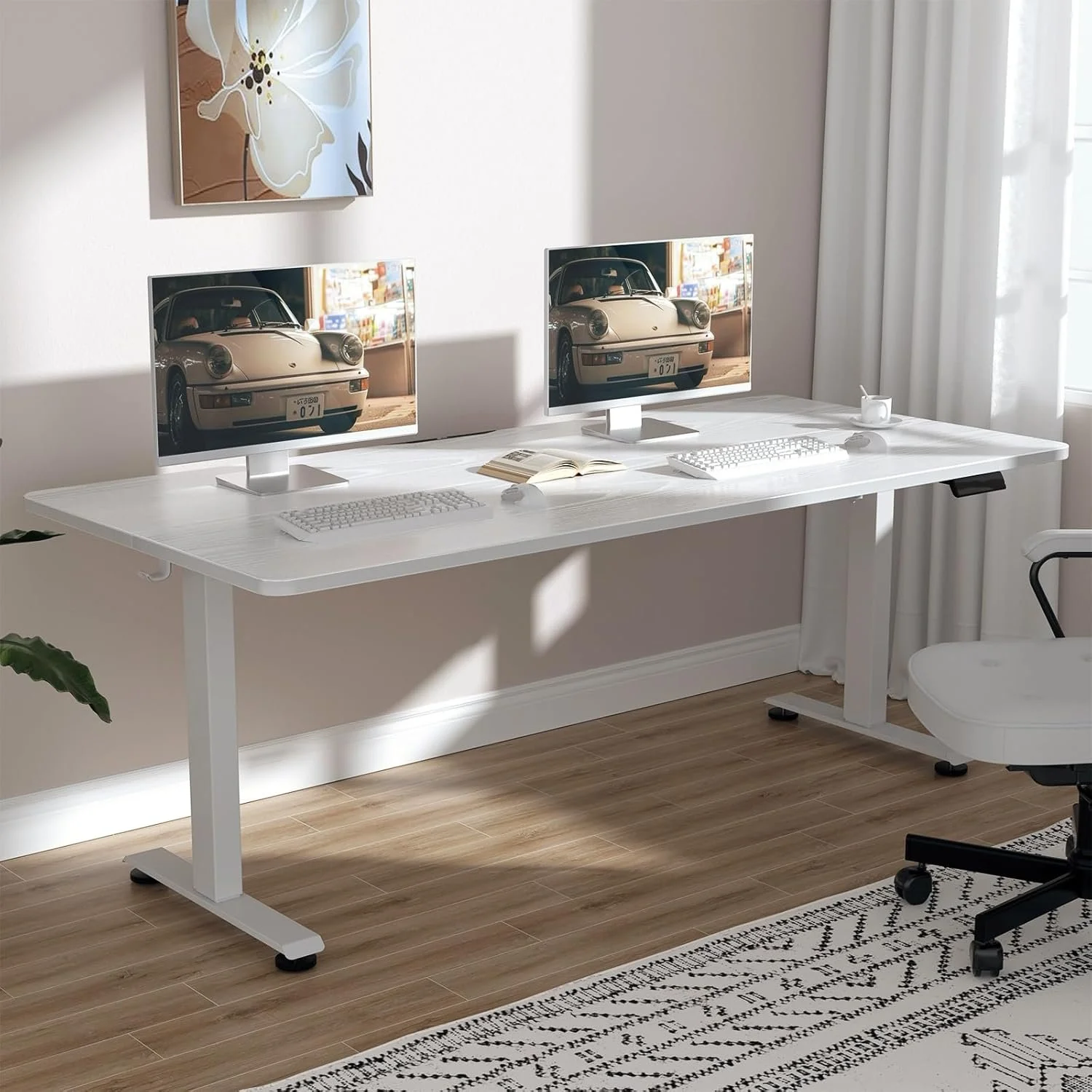 A white desk with two computer monitors, a keyboard, and a mouse, situated in a bright room with wooden flooring and white curtains. There is a plant on the left, a rug with black patterns on the floor, and artwork on the wall.