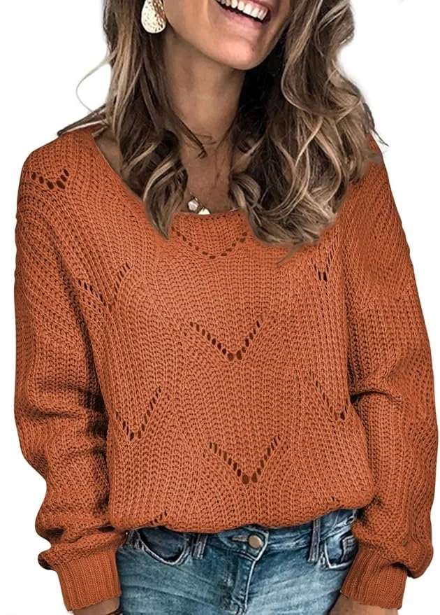 Woman wearing an orange knitted sweater with openwork patterns, blue jeans, and gold earrings, smiling.
