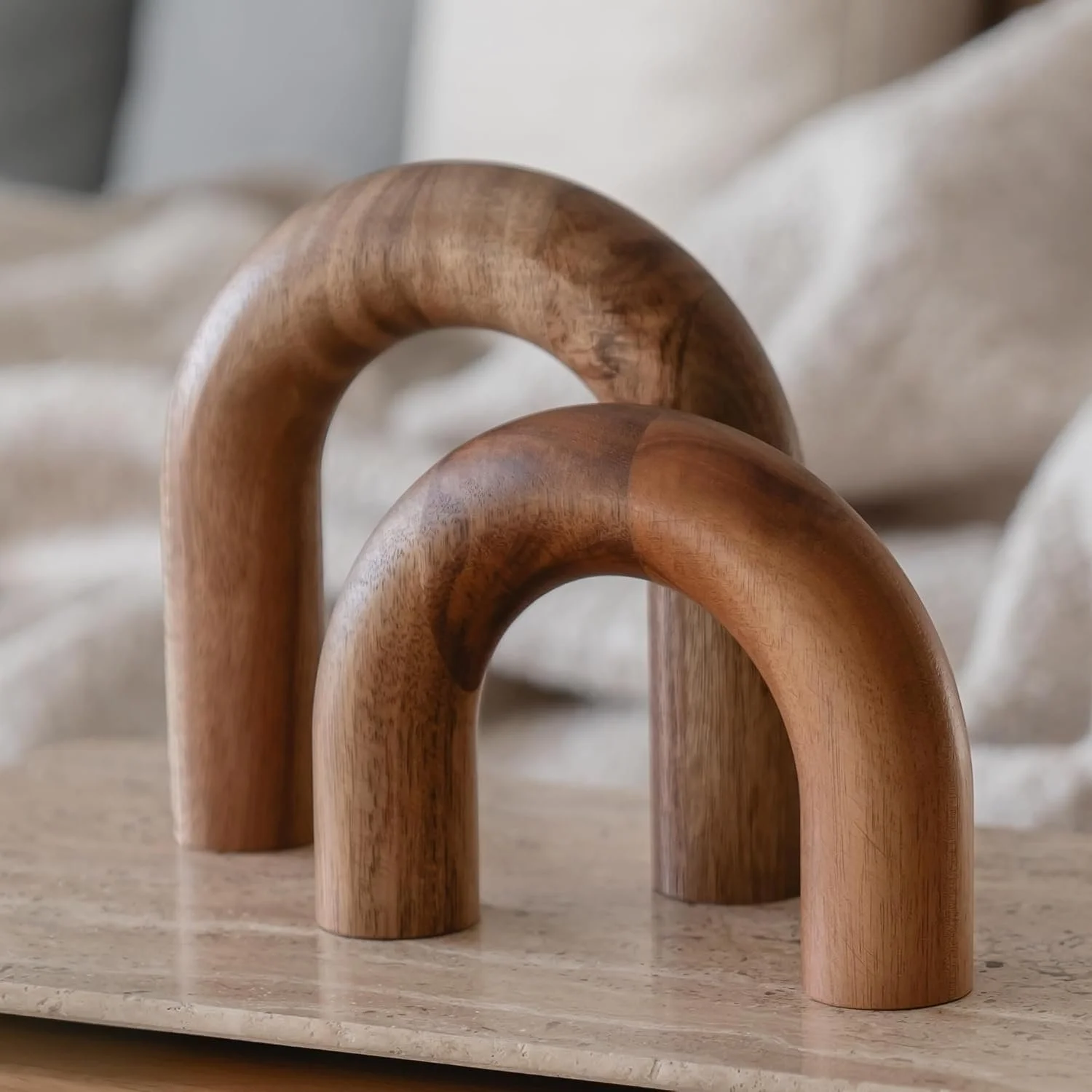 Close-up of three wooden bent handles standing upright on a surface, with a blurry background.