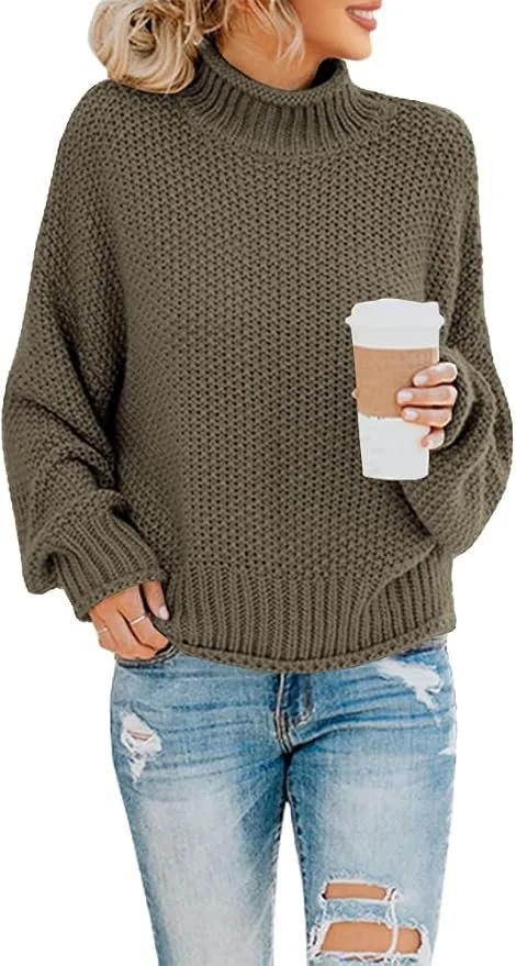 Woman holding a disposable coffee cup, wearing a green knit sweater and ripped jeans.