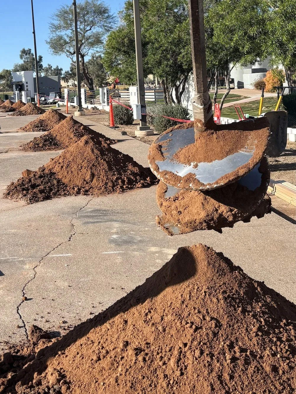 Row of drilled holes with spoil piles ready for removal on a Phoenix job site