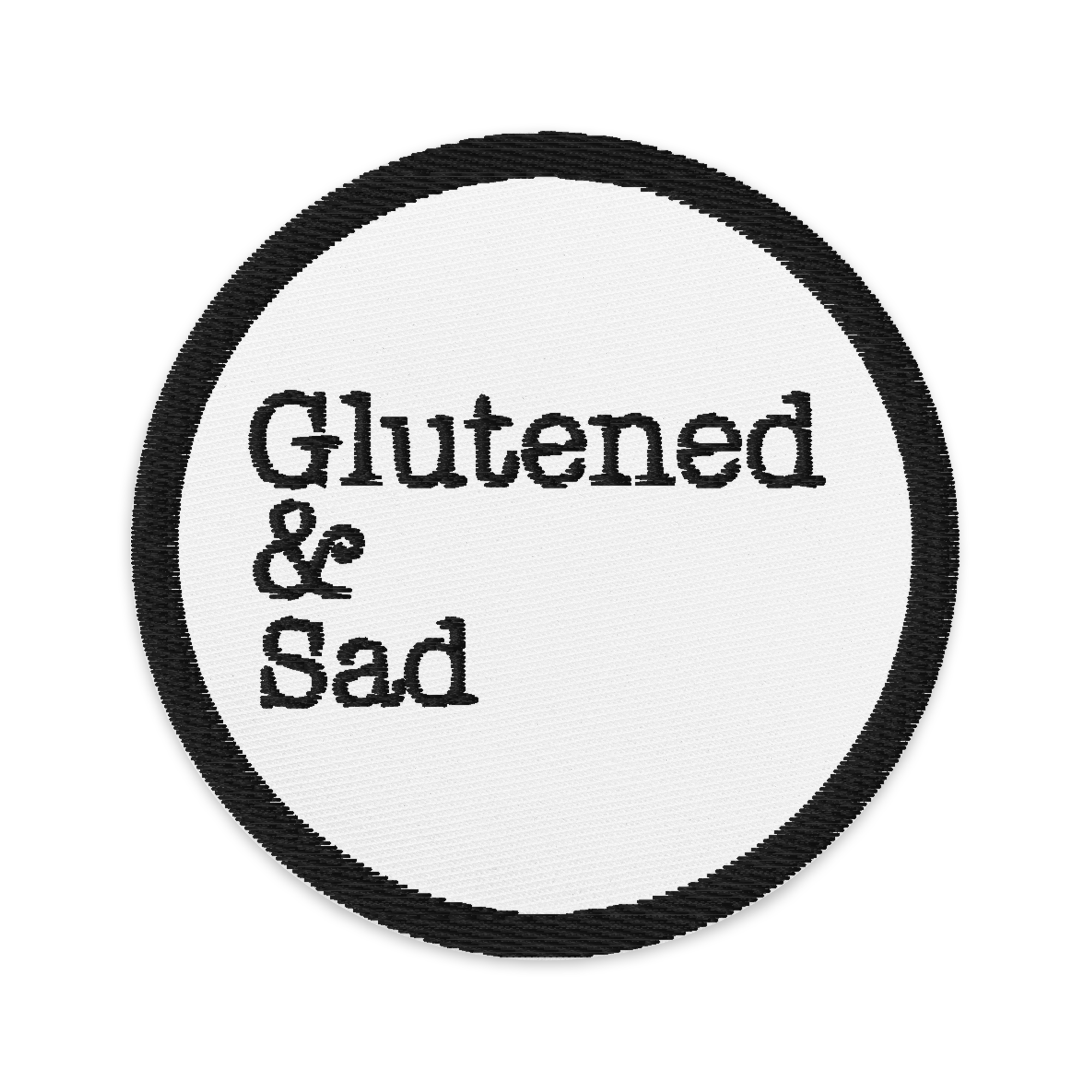 Close-up of a circular road sign with the word "Glutened" written on it.