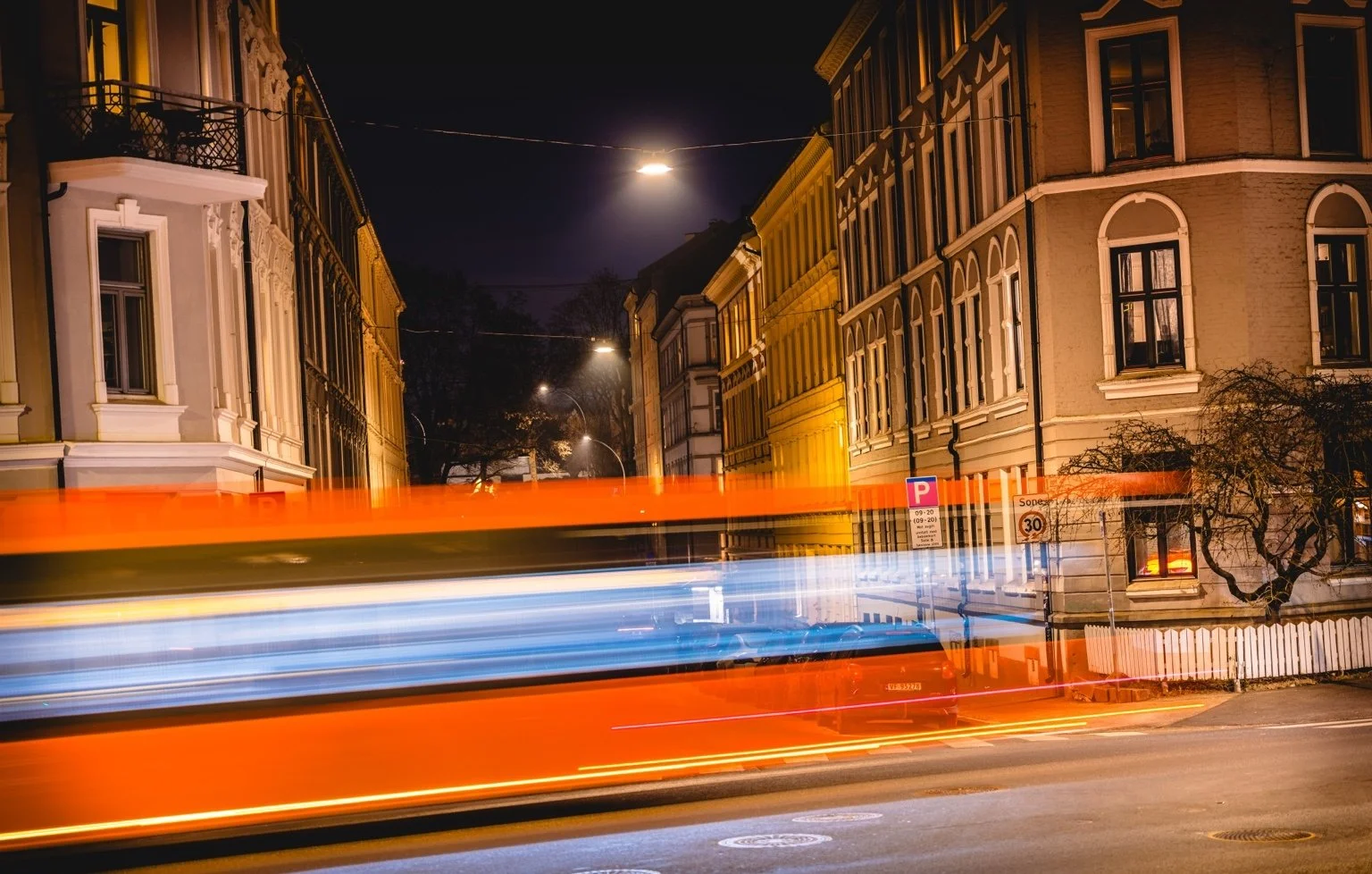 Abstract streaks of coloured city light moving through darkness.