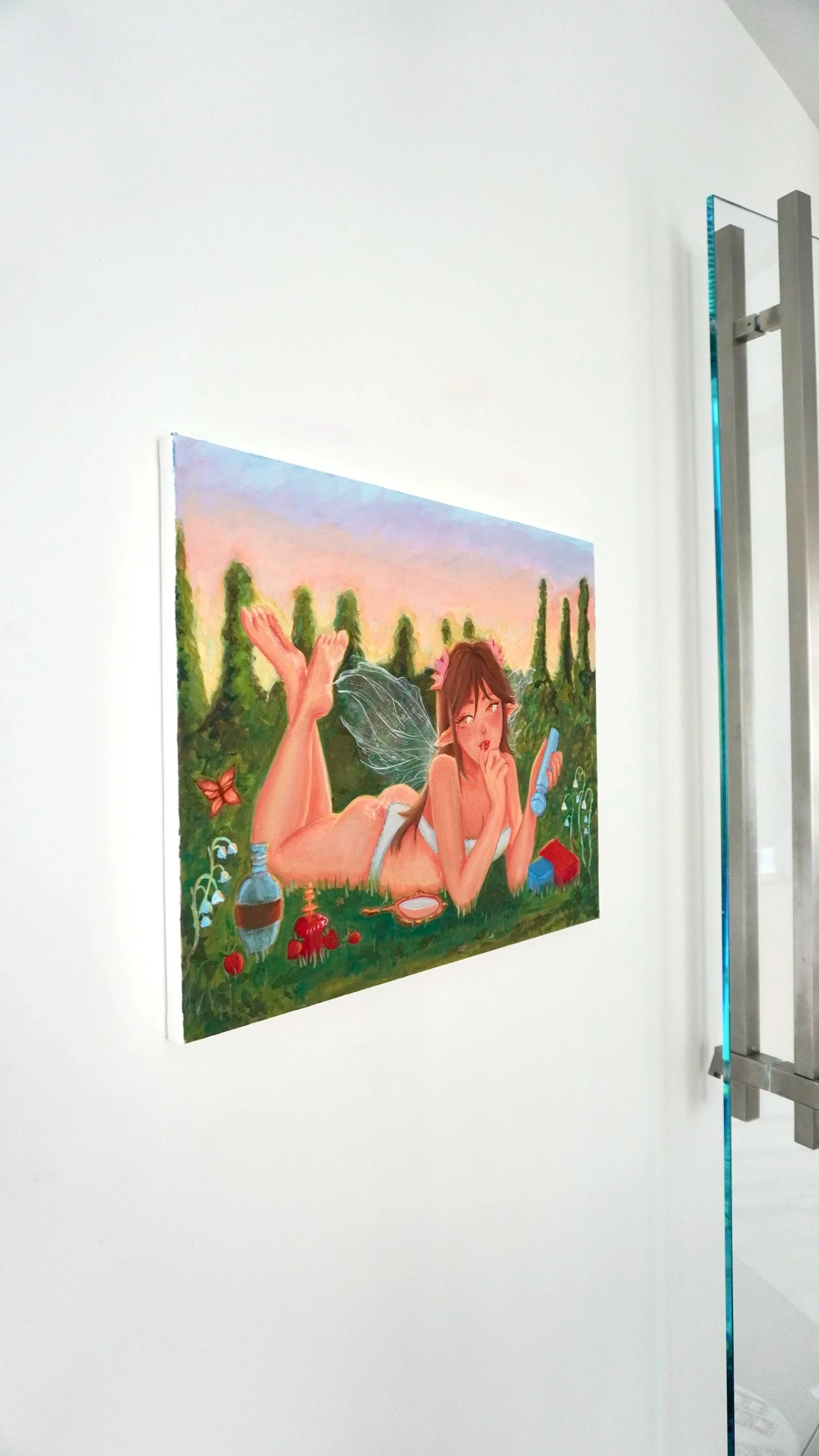A colorful painting of a woman with fairy wings lying on her stomach outdoors with trees and a sunset sky in the background.