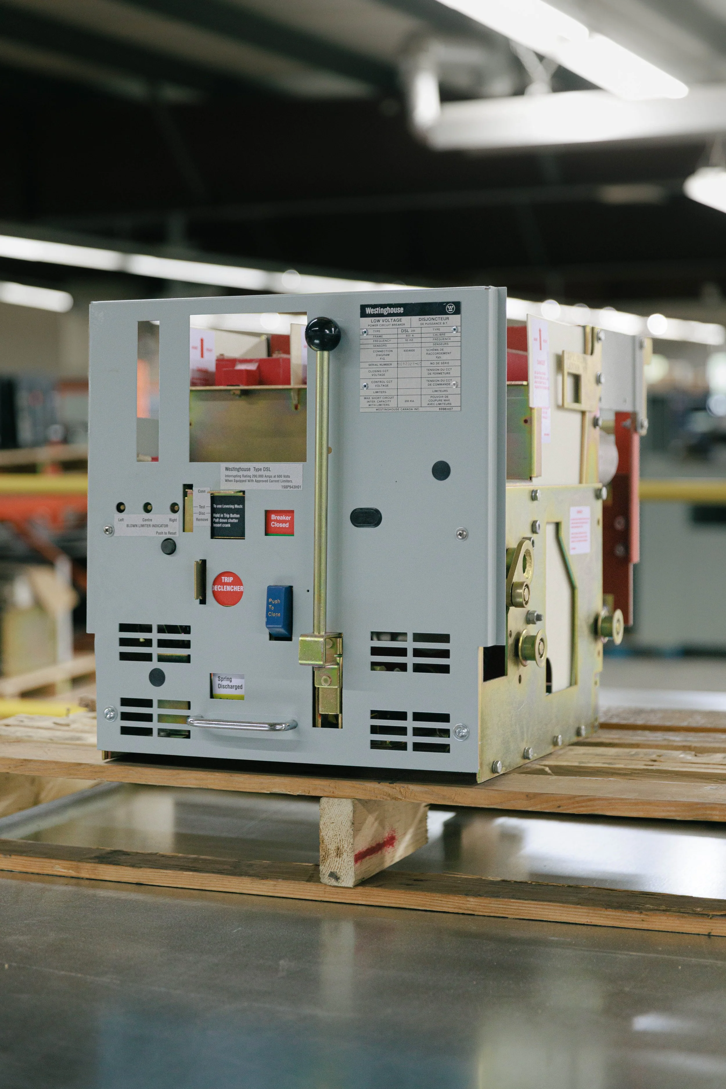 An industrial electrical device placed on a wooden pallet in a warehouse.