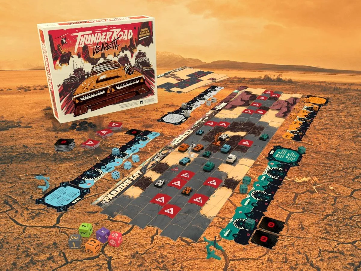 A board game setup called 'Tuner Road: The Movie' on a cracked desert surface with game pieces, dice, and cards laid out. The box art features a car in a desert scene with cars and explosions.