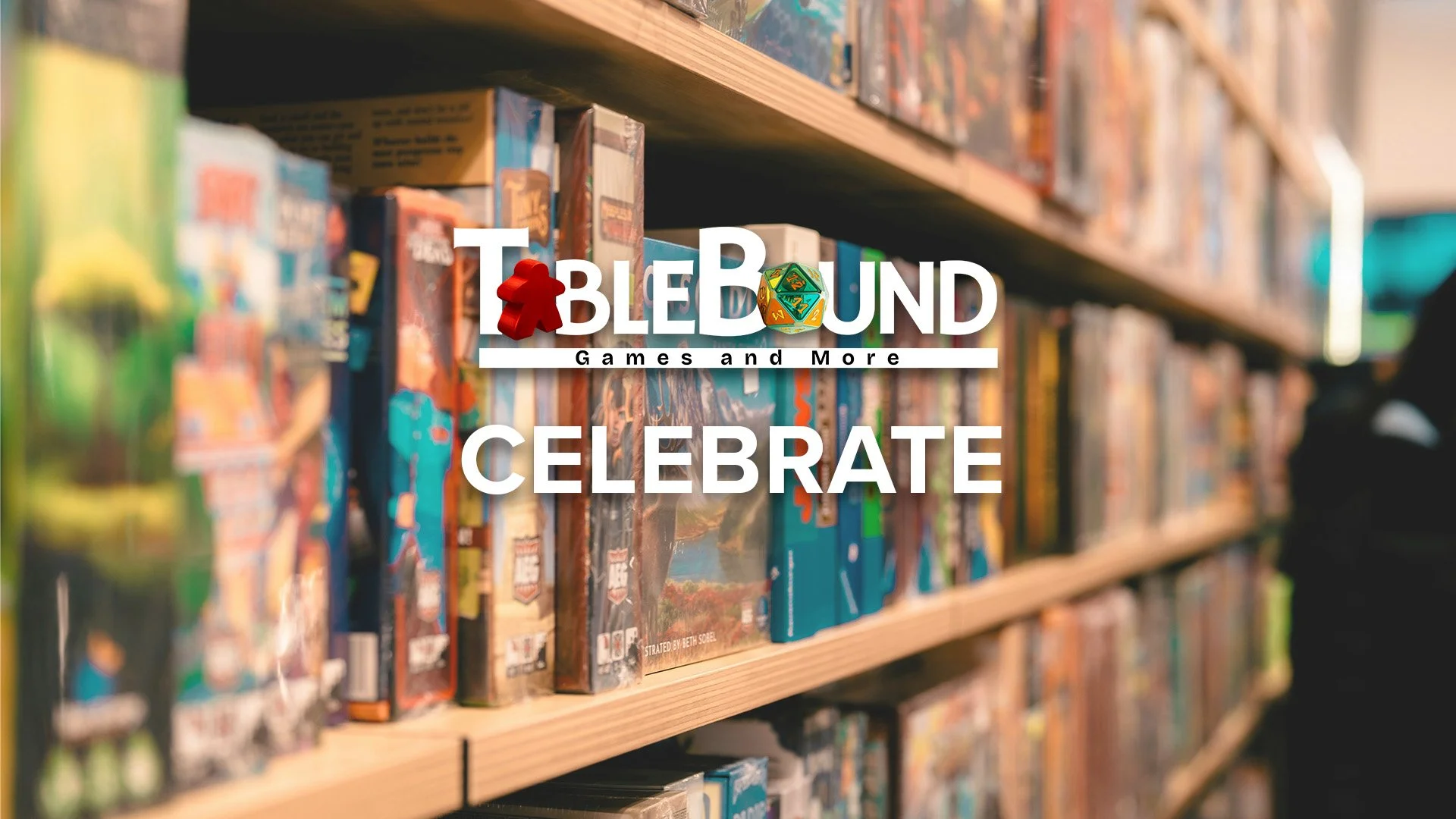 A bookshelf filled with various board games and tabletop games at a store, with a logo overlay for 'Tablebound Games and More' and the word 'Celebrate'.
