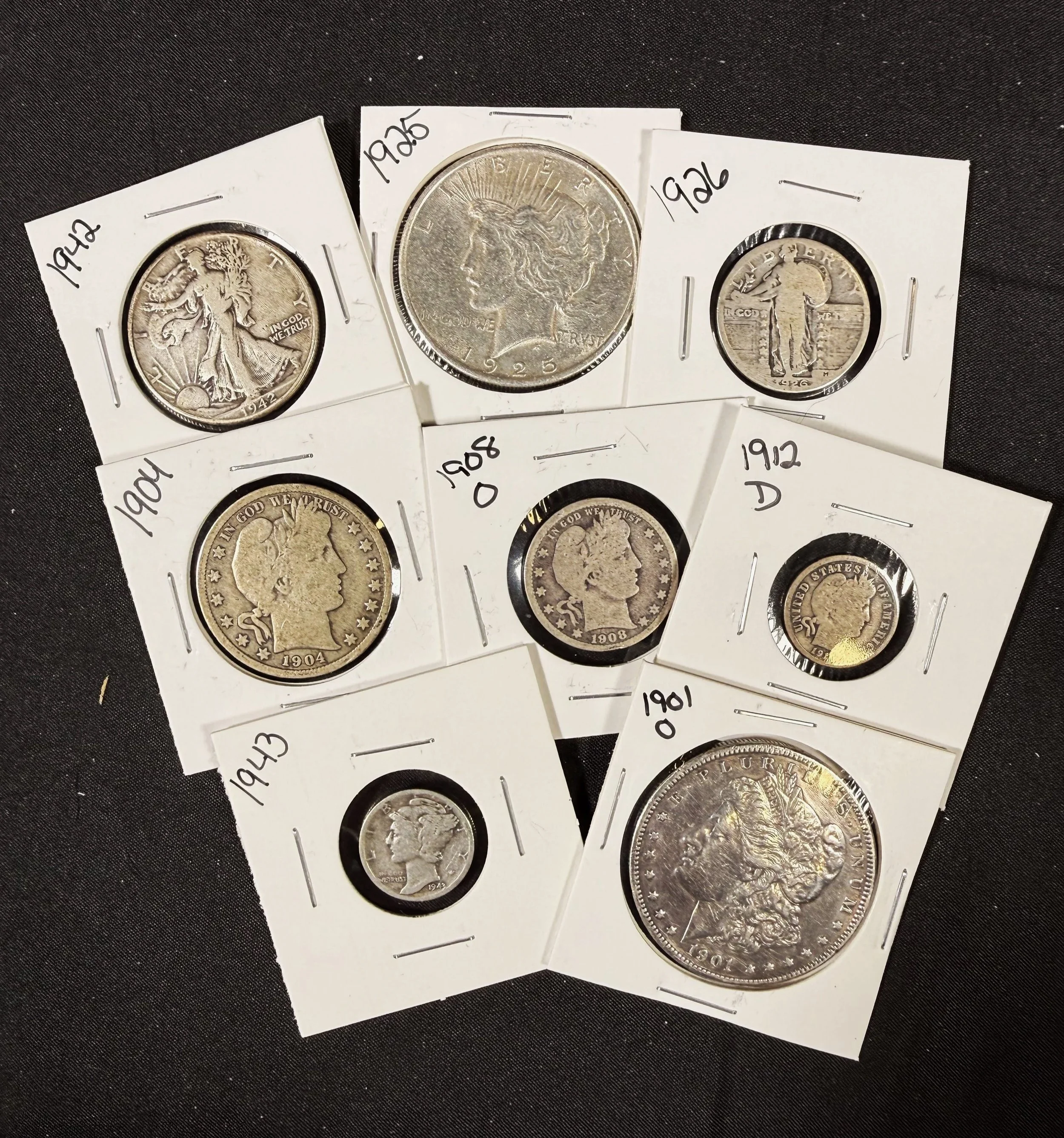 Four Mercury dimes in white coin holders, with handwritten year labels including 1904, 1906, 1912, and 1942, on a black background.