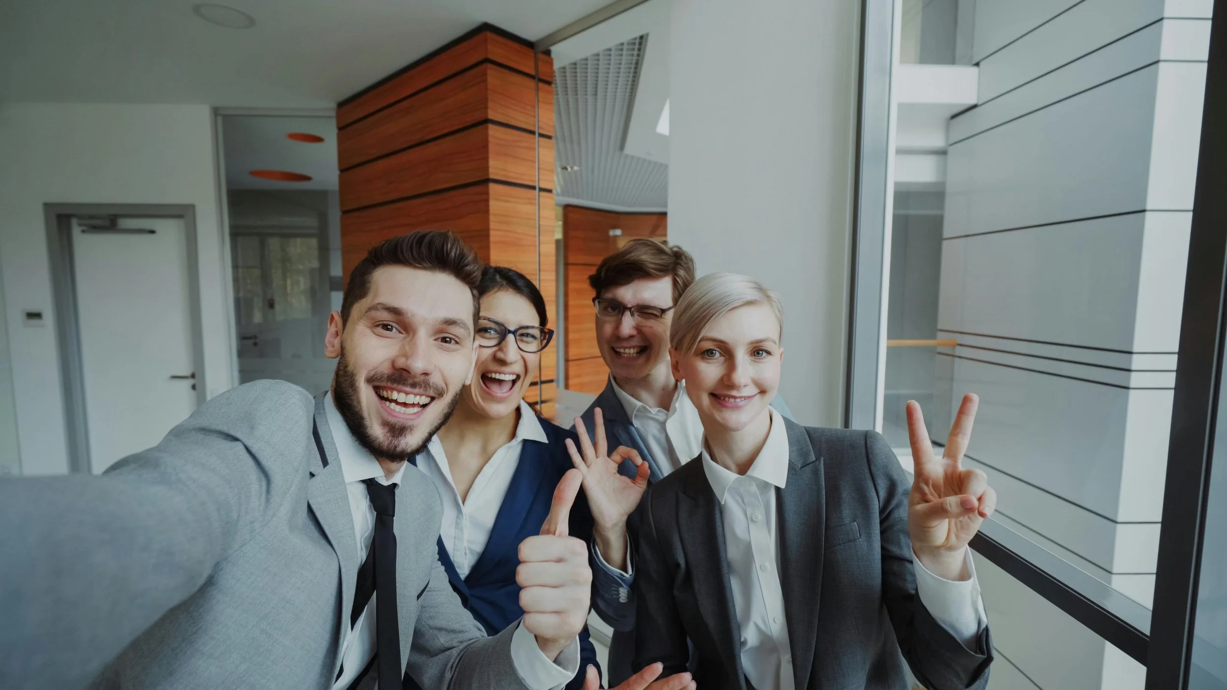 Ah, for the alt text, you could say something like: "A group of four coworkers smiling together while taking a selfie, capturing a fun and collaborative moment.