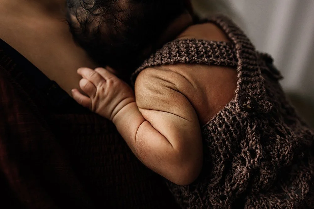 Newborn baby in a brown onesie, lifestyle newborn photography Darwin NT