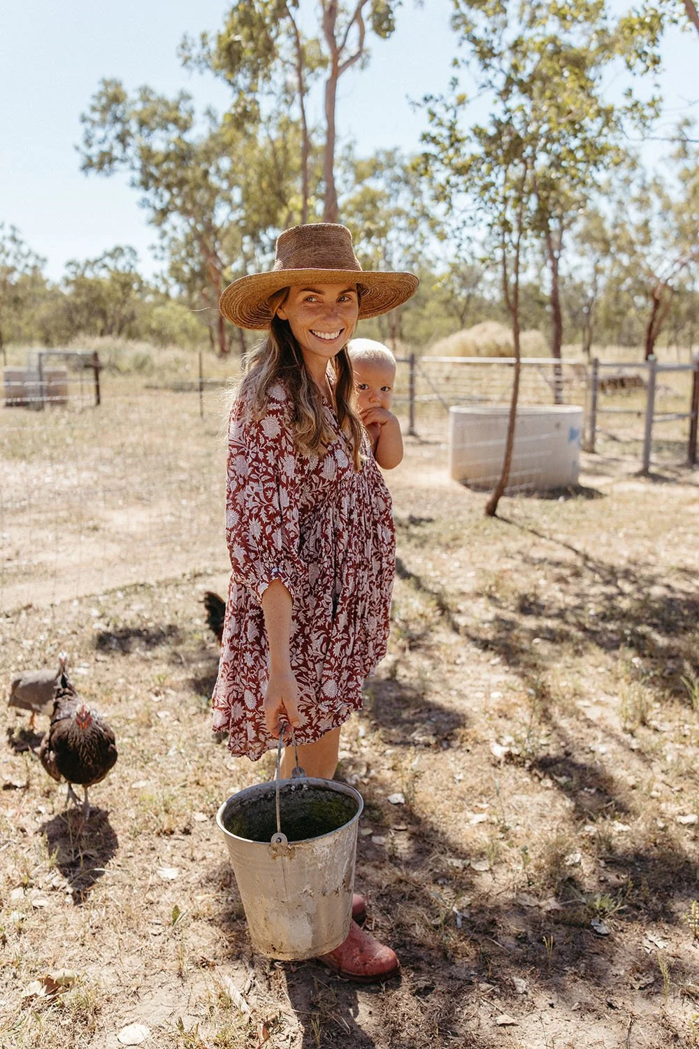 A woman holding a toddler on a farm in the NT.  Rural family photography shoot, Captured by Cody Photography.
