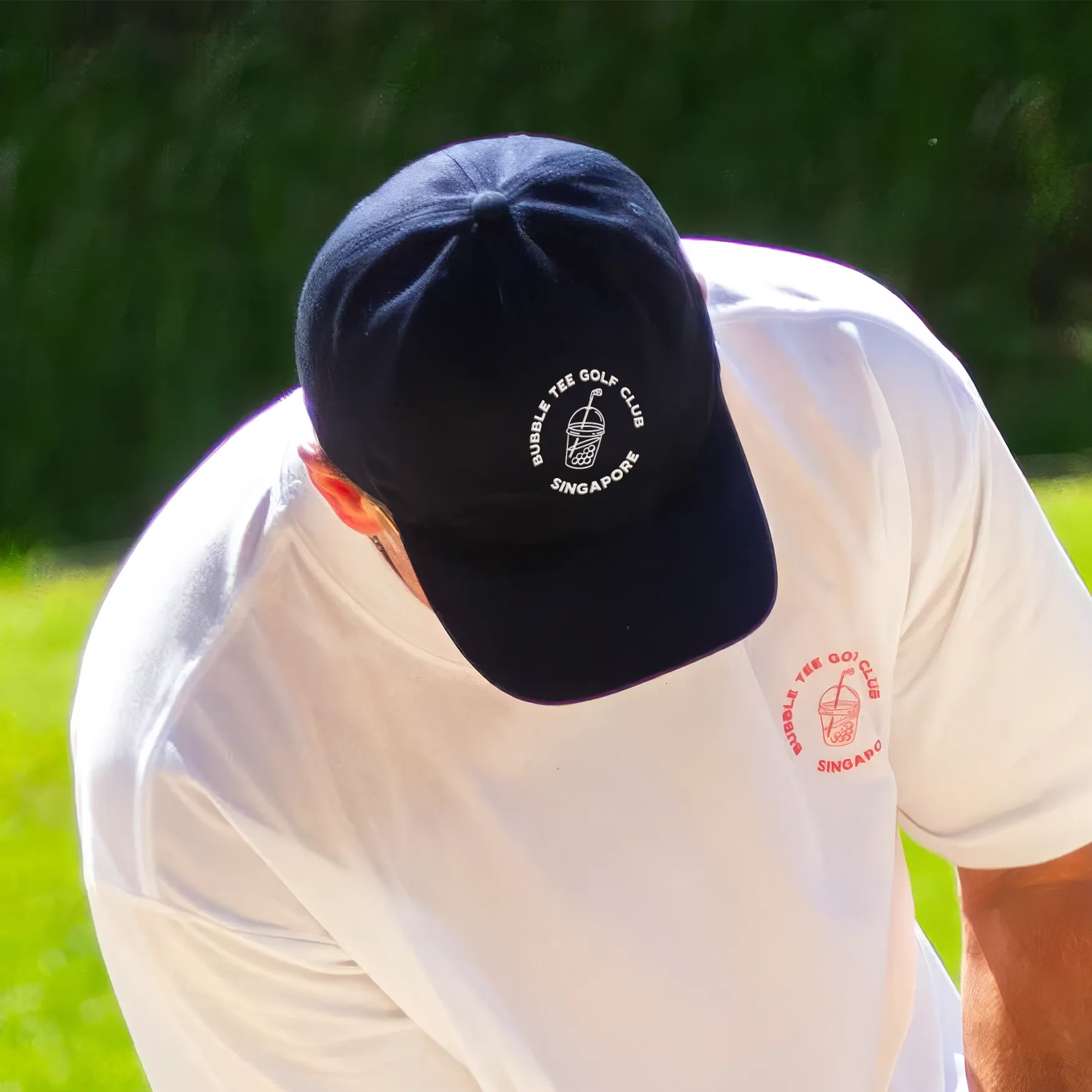 Close-up of male golfer wearing a navy blue Bubble Tee Golf Club Singapore cap with embroidered logo, styled for the golf course, modern streetwear-inspired golf apparel.