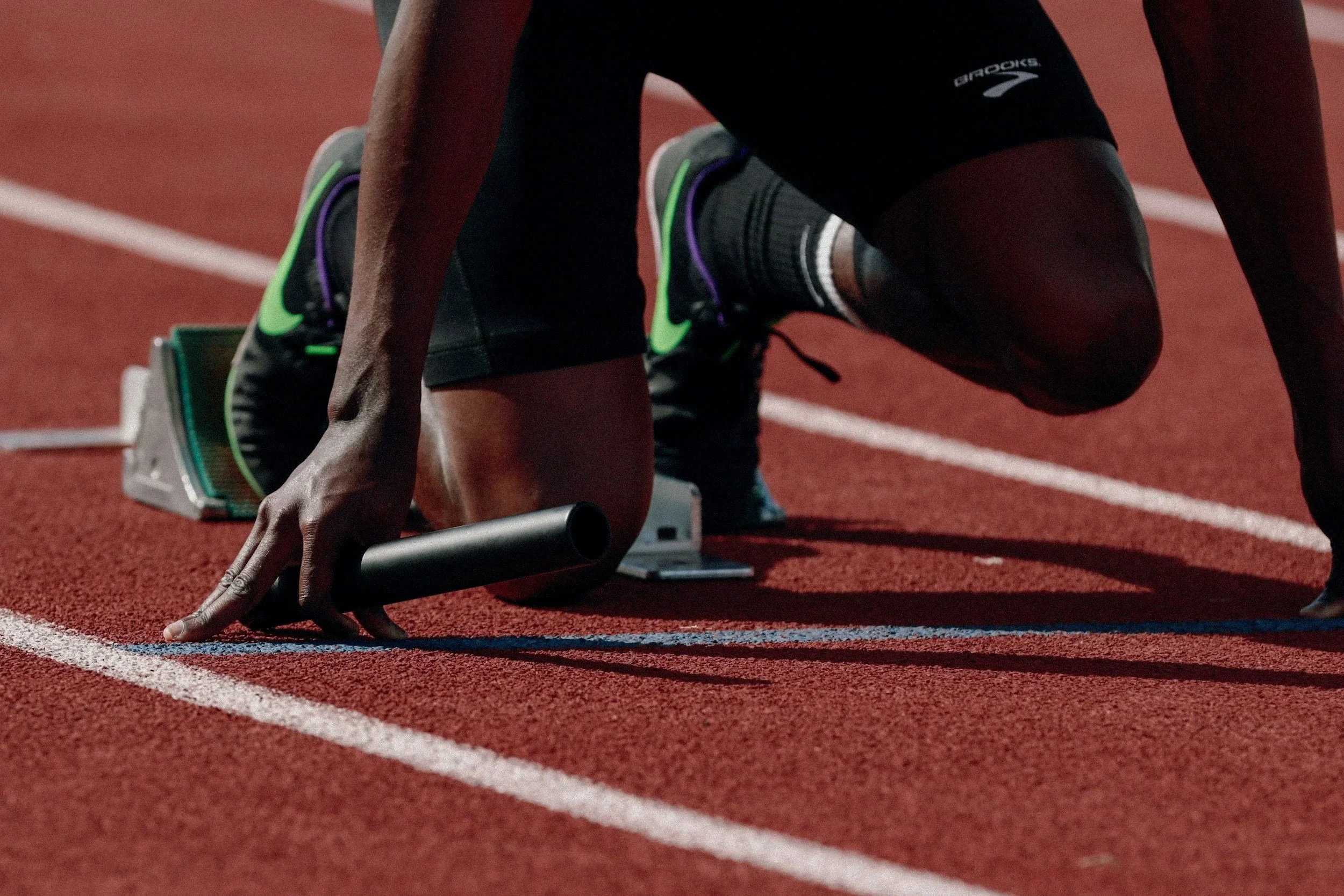 Competitive athlete preparing for a sprint — illustrating the mental and physical demands Ryan Chhajed addresses in athlete performance coaching.