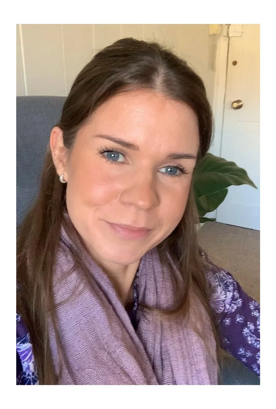 Counsellor in Canterbury - a woman with blue eyes and long hair smiling warmly from cosy chair