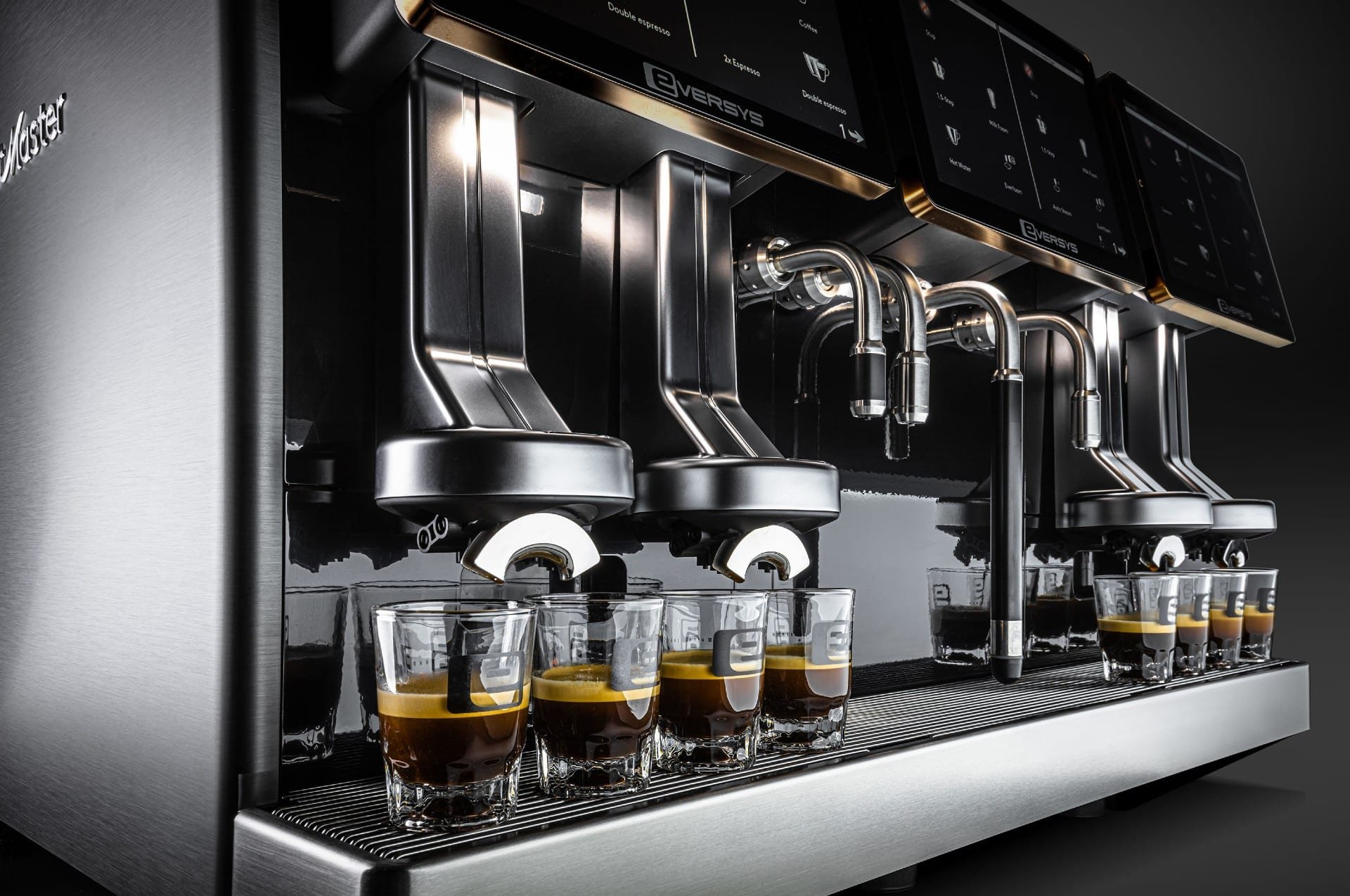 Close-up of a Eversys Cameo espresso machines with four glass cups filled with espresso, connected to the machine’s brewing nozzles.