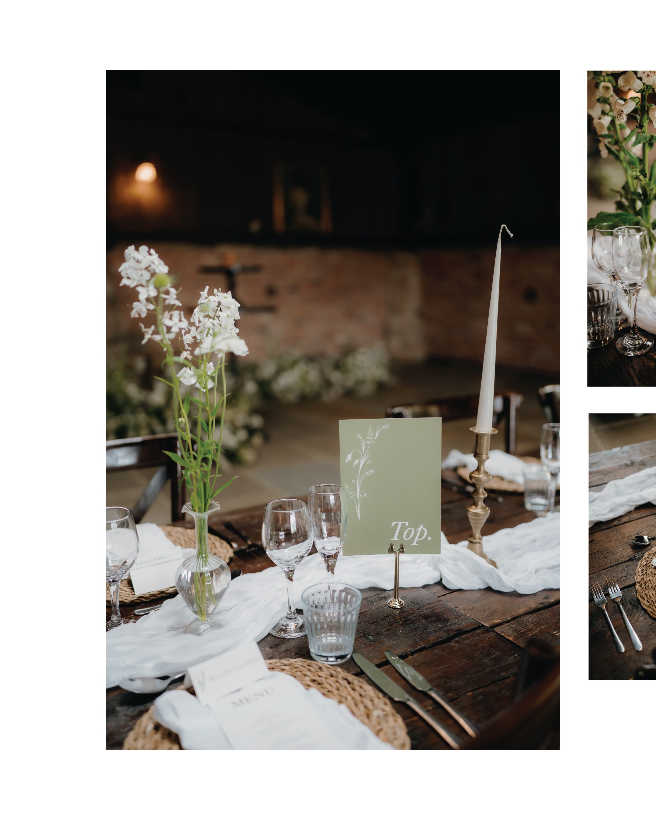 A rustic wooden table set for a formal dinner with glassware, cutlery, and floral centerpieces, including white flowers in a glass vase and greenery. There are white cloth napkins and printed menus place cards, with a cream-colored cloth runner across the table.