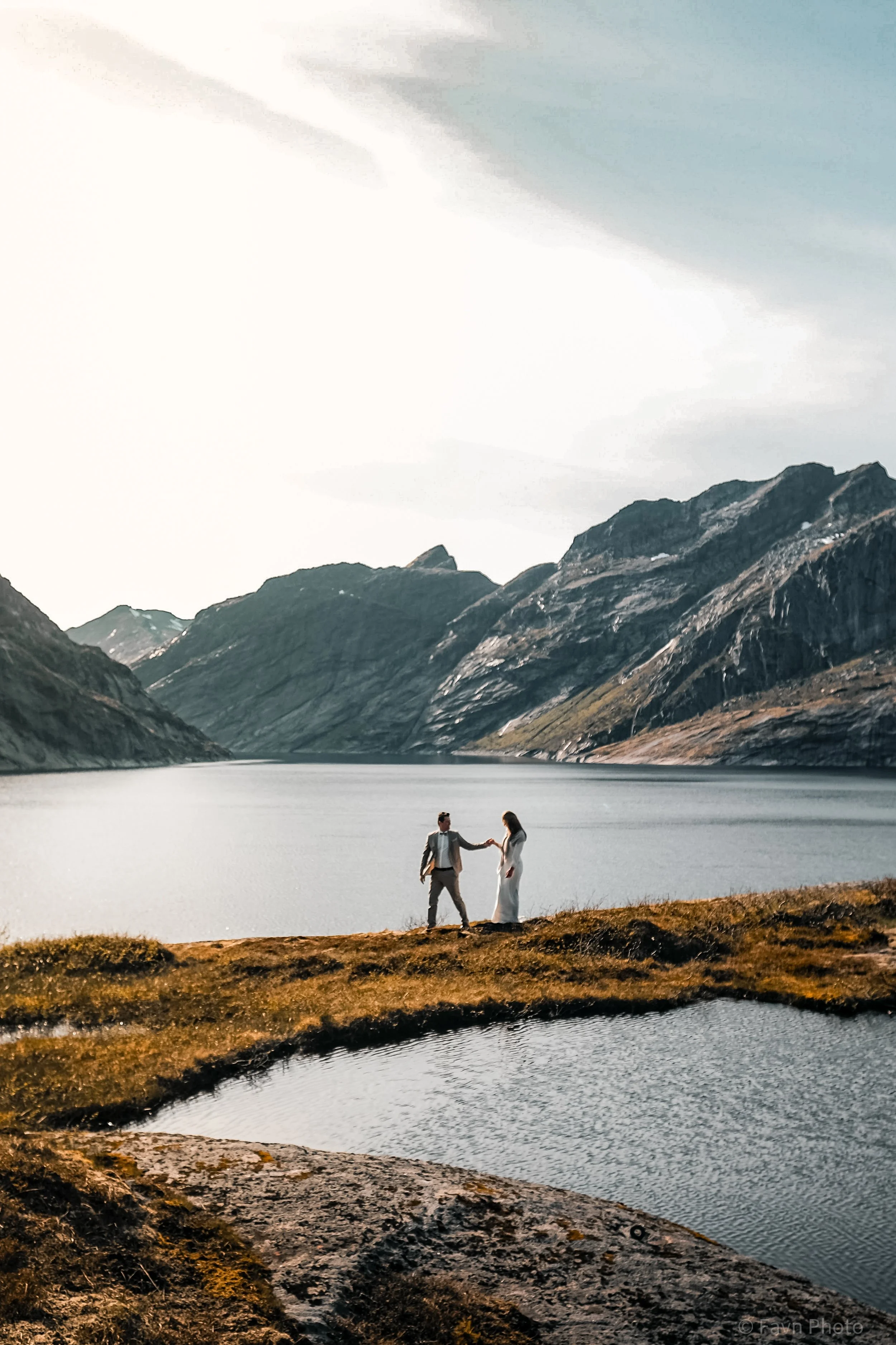 Heldagsfotografering bryllup. Elopement i Lofoten med fjell og innsjø i bakgrunnen.
