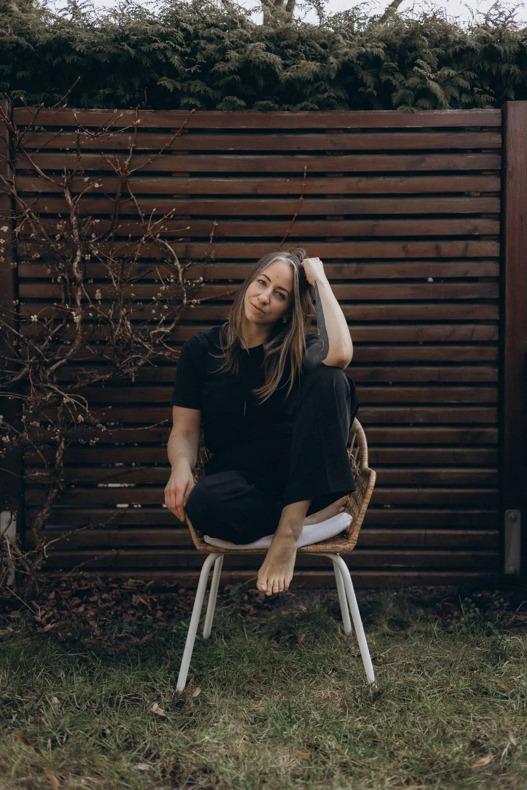 Frau sitzt nachdenklich auf einem Stuhl im Garten – Amanda Chambour, Identitäts-Coaching für Frauen