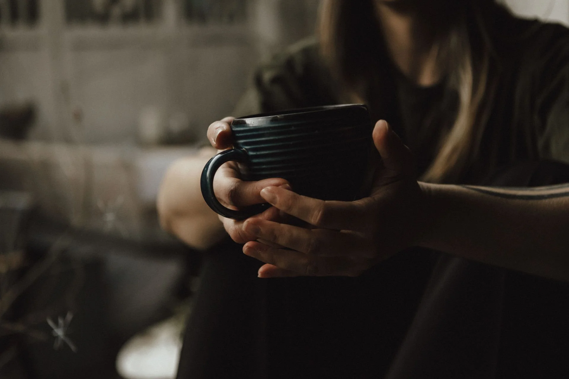 Kaffeetasse in den Händen nachdenklicher Frau