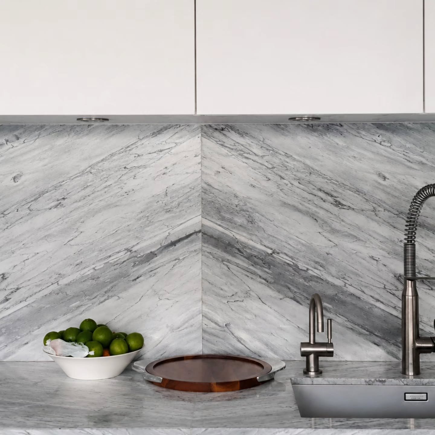 Stone has its own grain and movement before anyone touches it. What changes everything is how it's laid. 

A straight bookmatch mirrors the veining across a seam, like the pages of a book. A chevron like this, from our Rathgar Mews project, takes tha