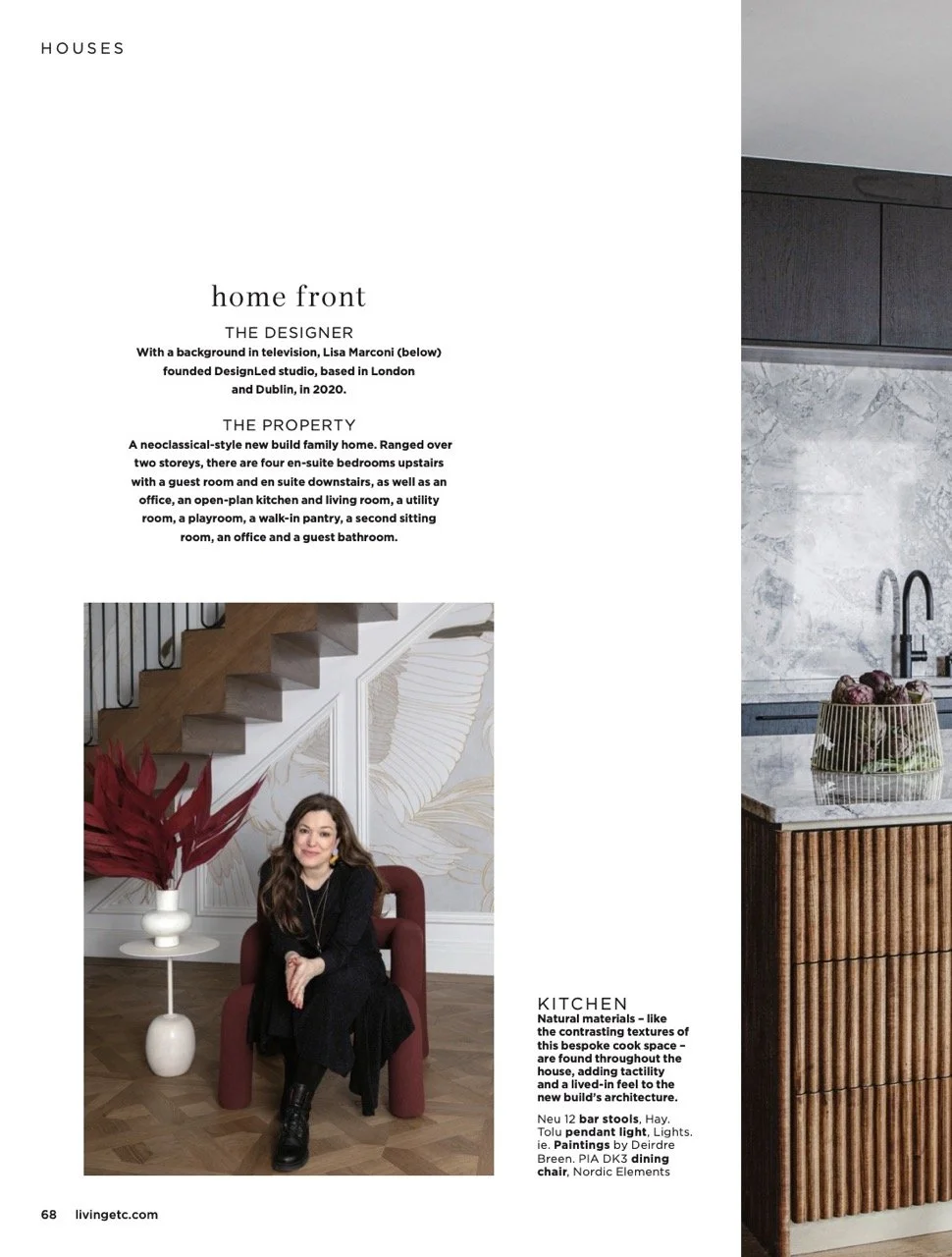 Page from a magazine featuring a real estate property with a modern kitchen and a portrait of a woman sitting in a living space with decorative wallpaper and a red armchair.