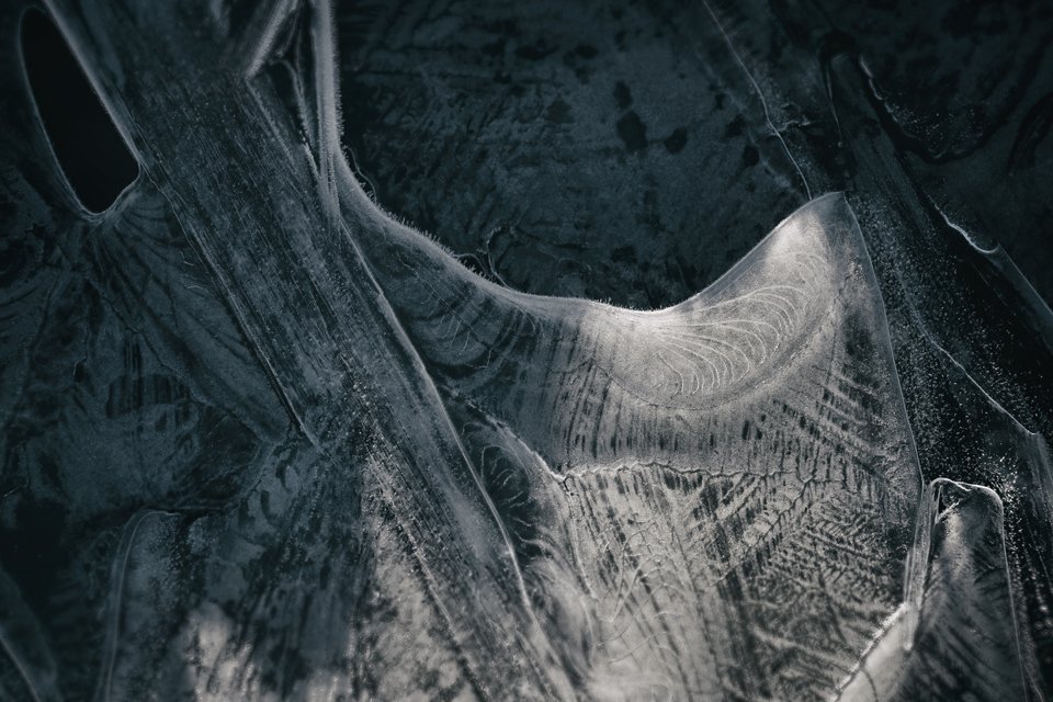 Close-up of ice with intricate crystallized patterns and cracks.