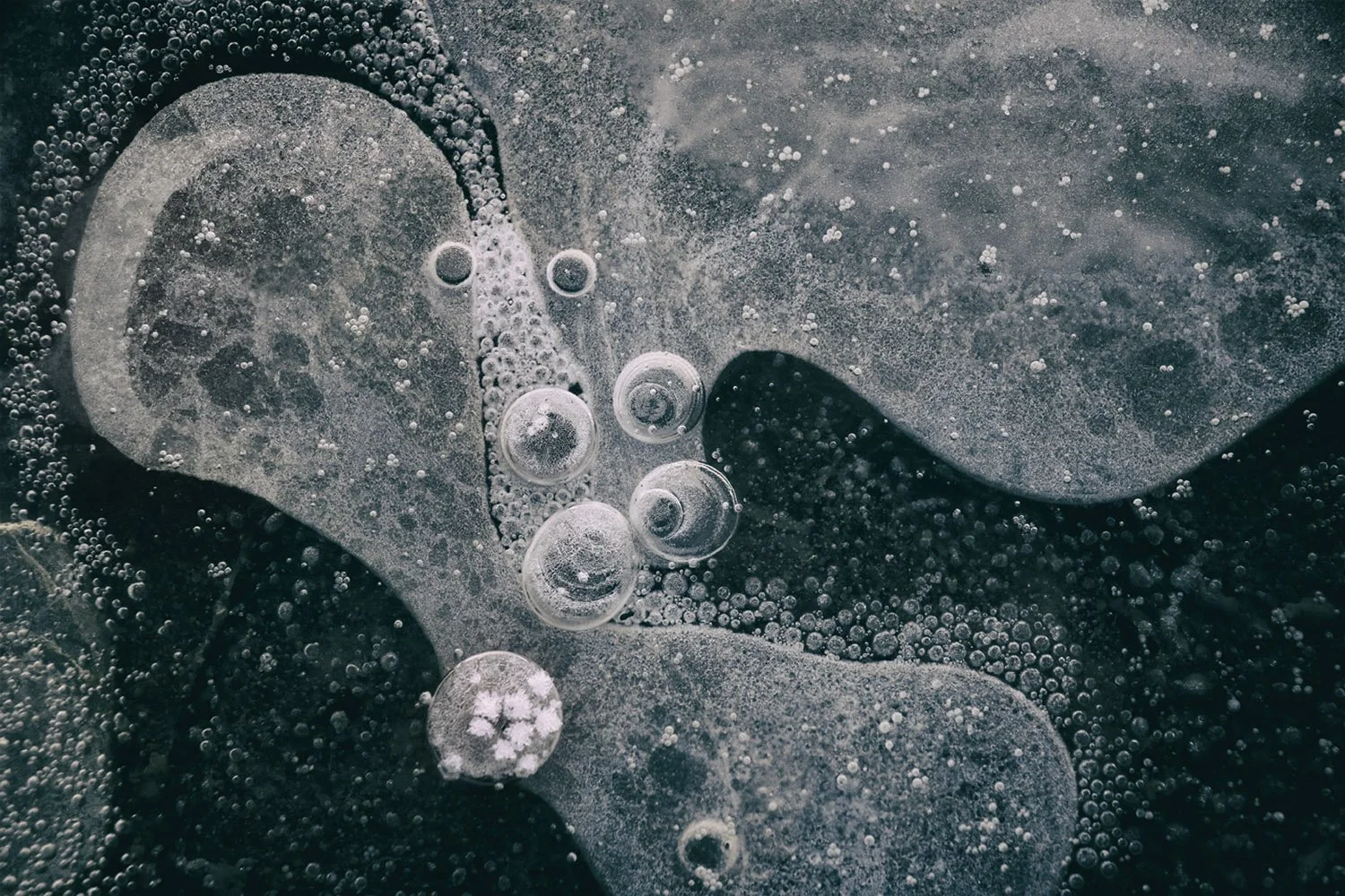 Close-up of bubbles and ice formations on a surface, with various bubble sizes and textures.