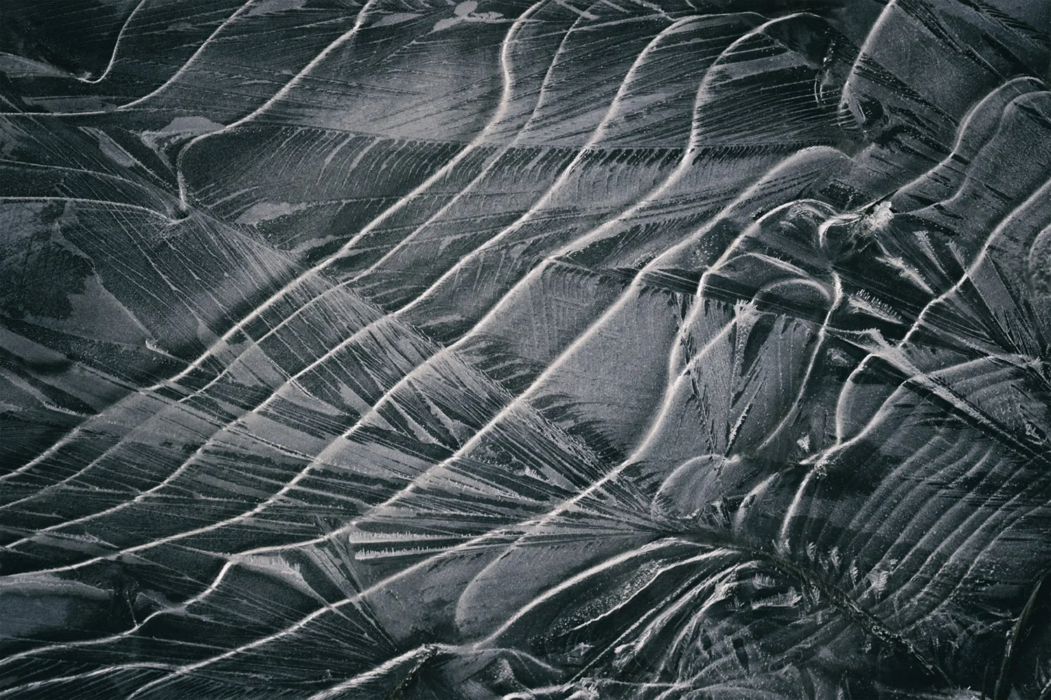 Close-up of a textured icy surface with streaks and lines.