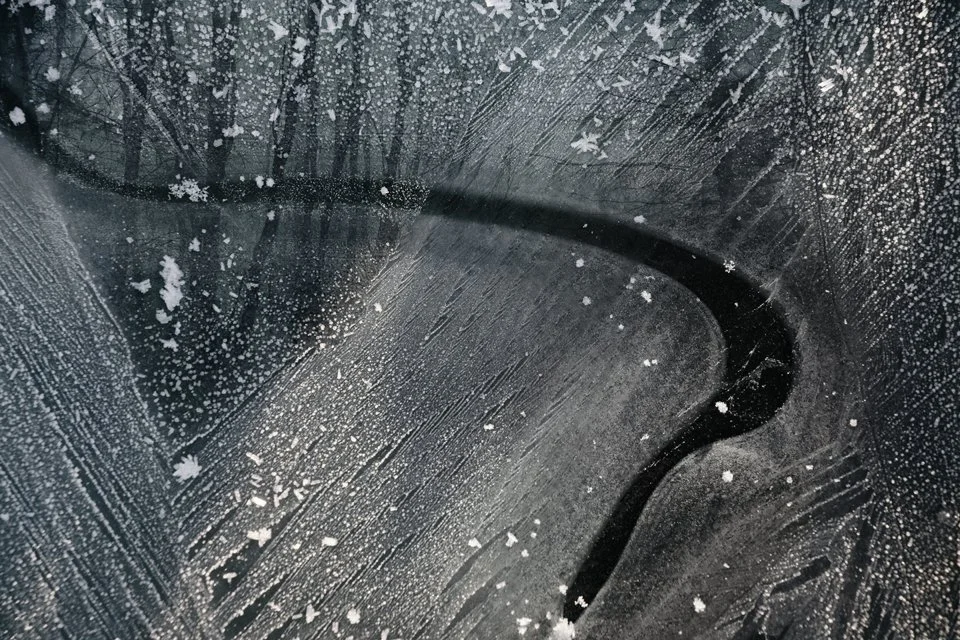 Close-up of icescape with  frost patterns and overlayed trees