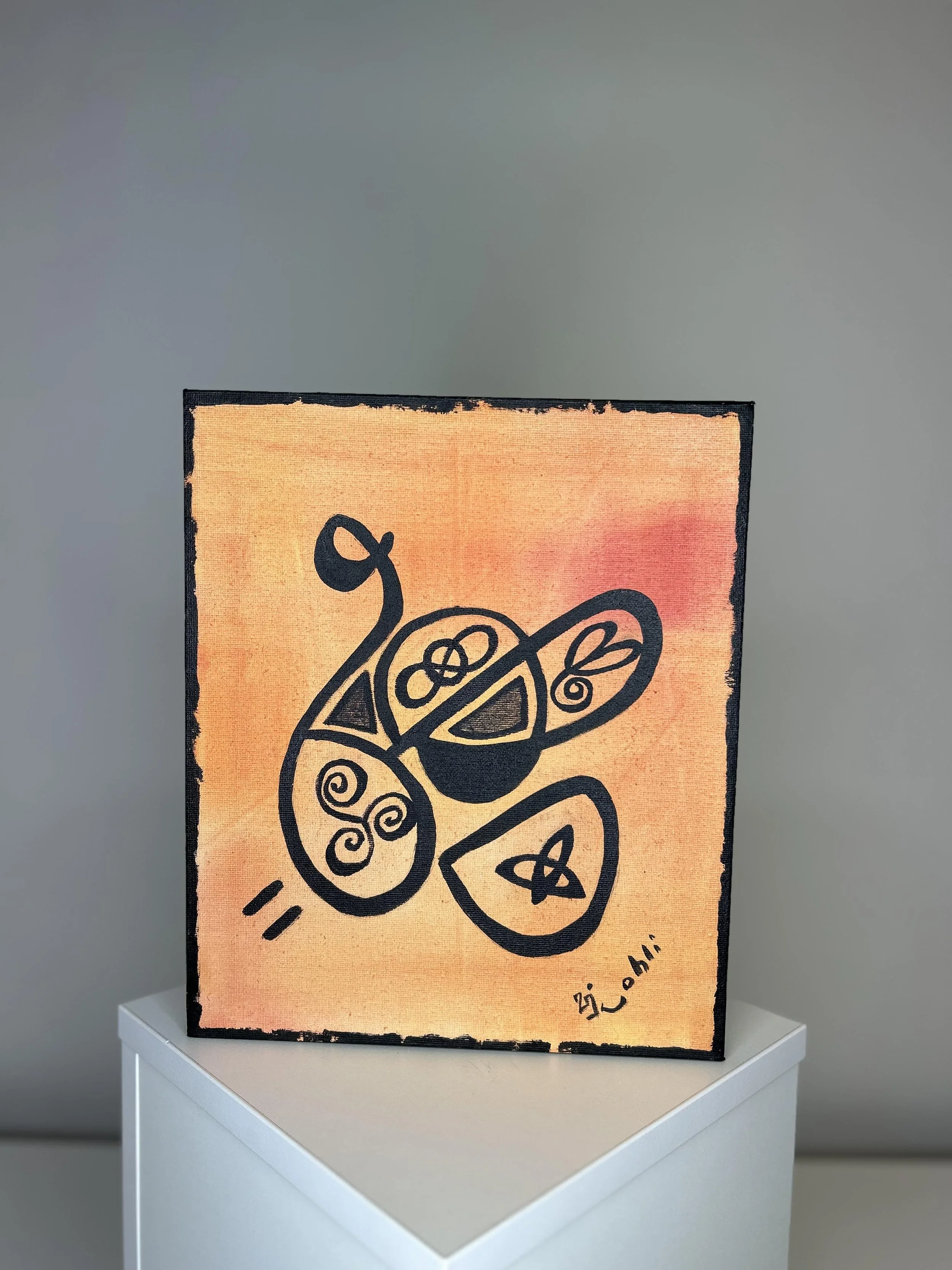 A rectangular artwork with a pink and orange background features a black line drawing of a snake with coiled body and head facing to the left. The artwork is displayed on a white pedestal against a plain gray wall.