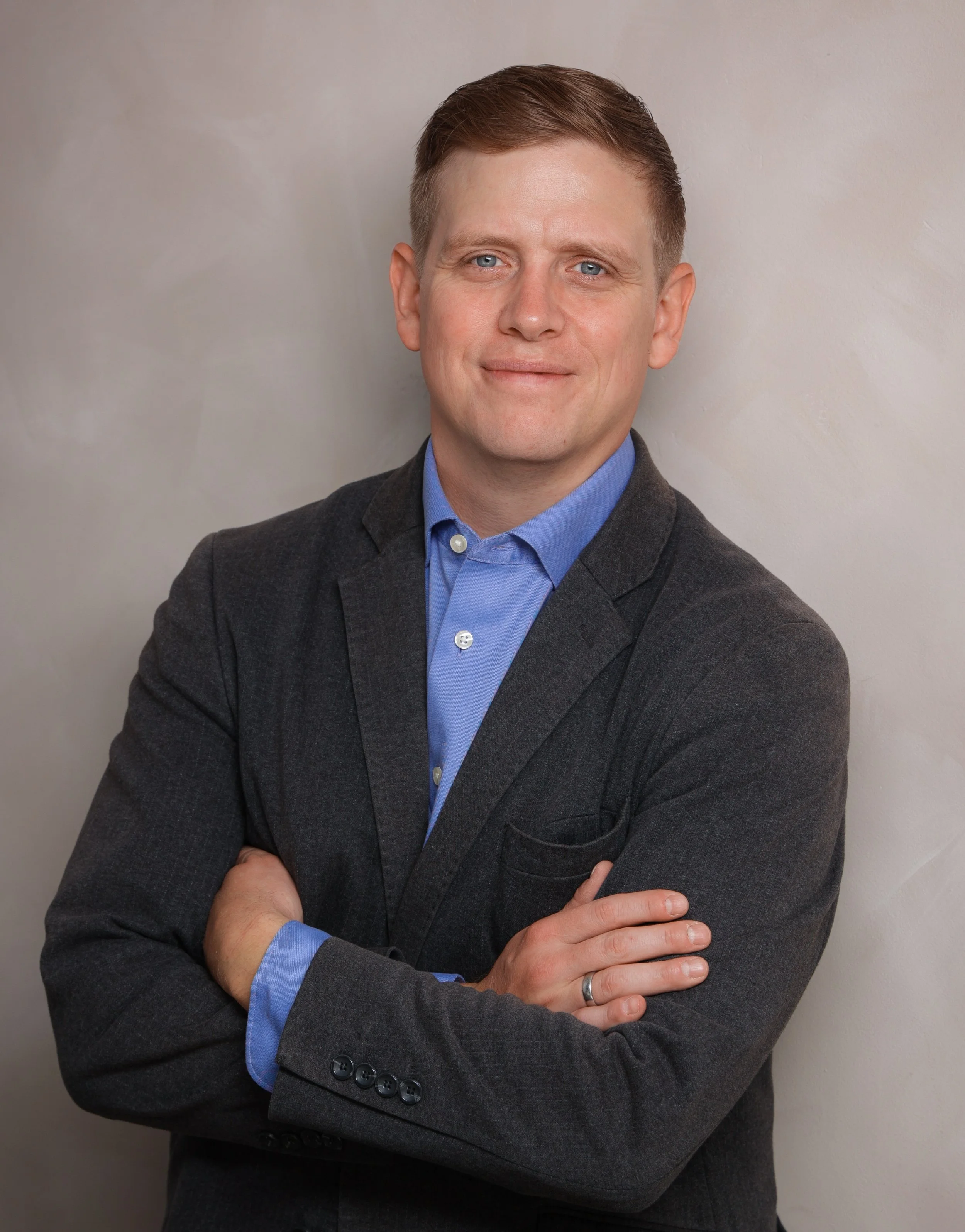 Michael James Przybylek, founder of Critical Project Management, wearing a blue shirt and dark blazer