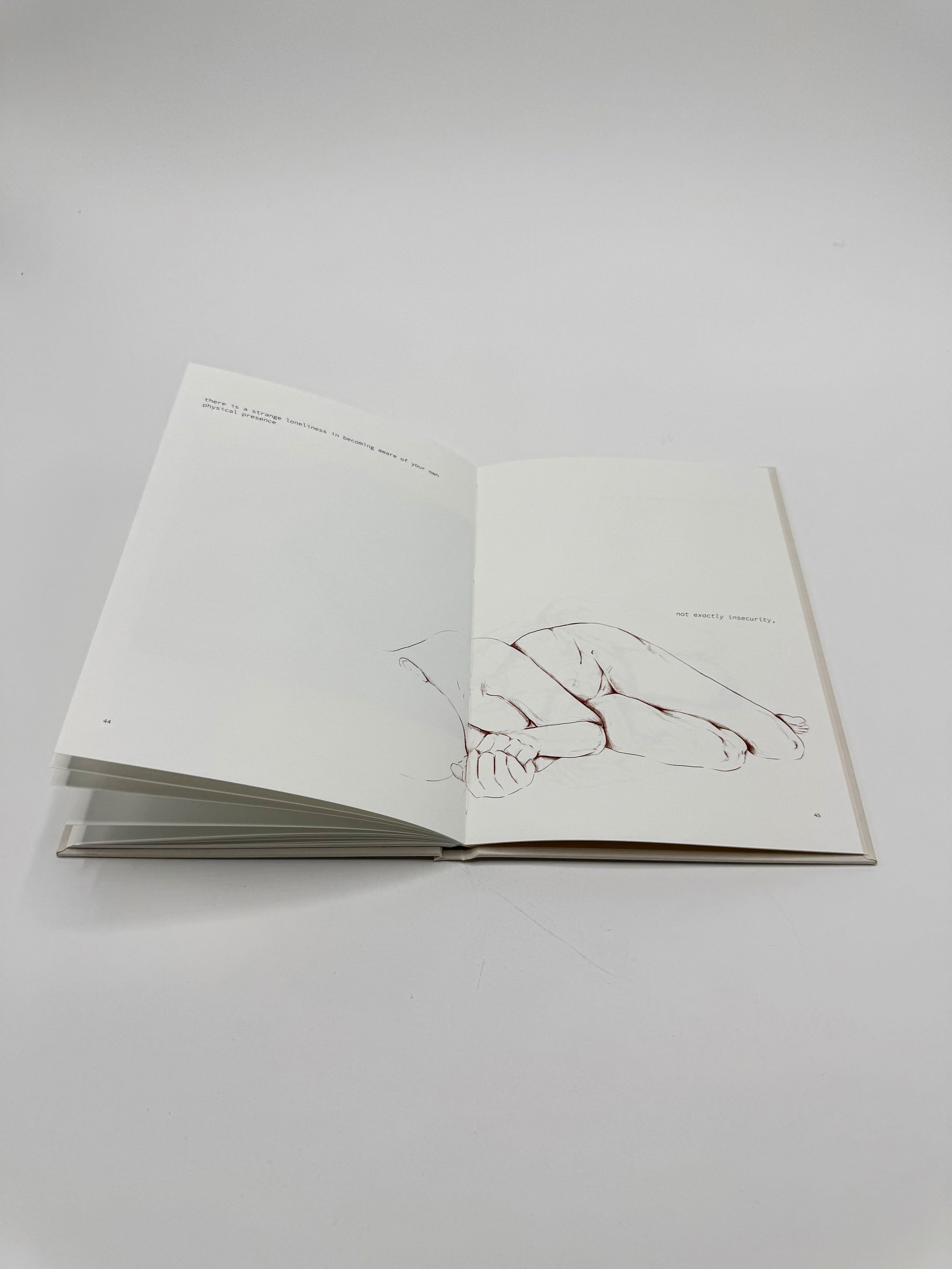 Open book showing a sketch of a reclining woman and lines of text on white pages.
