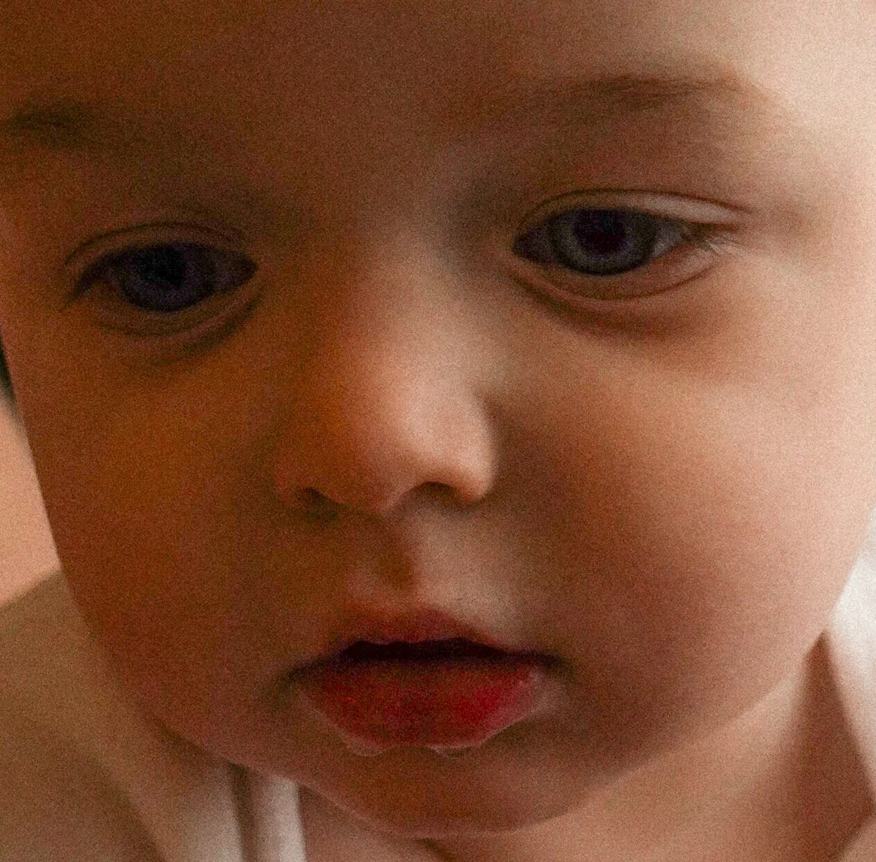 Close-up of a young child's face, focusing on the eyes, nose, and lips, with soft lighting.