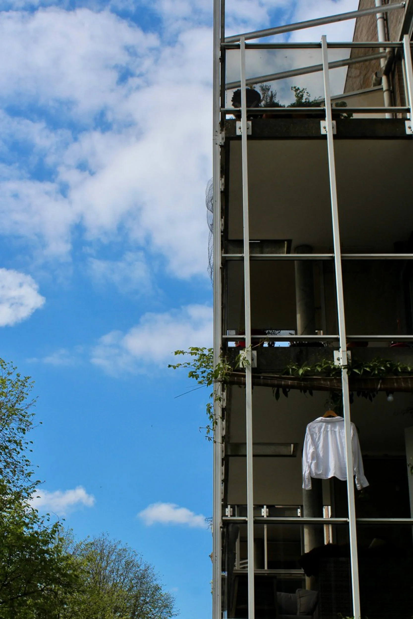 Amsterdam balcony with laundry and plants against a blue sky. Everyday life photography by Isabel Hachmann-Peralt.