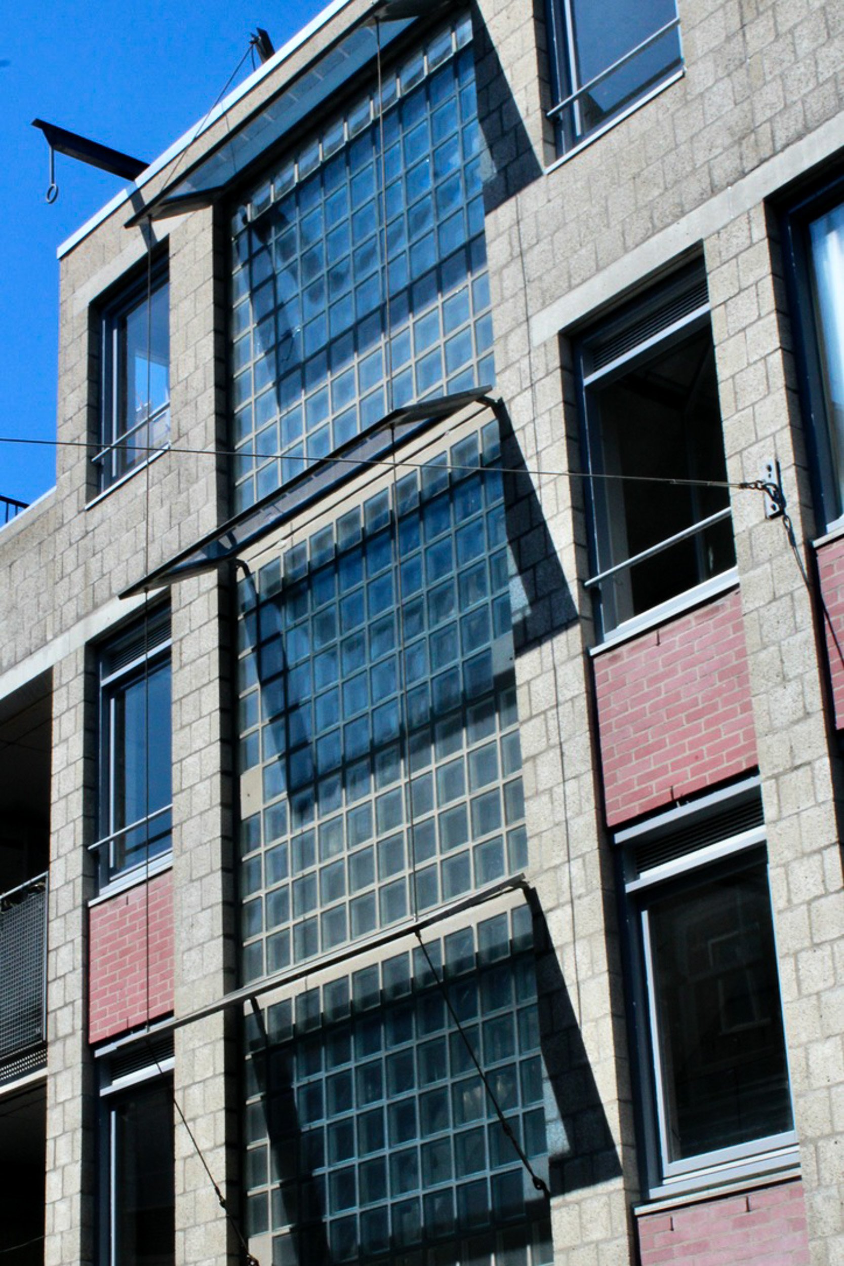 Modern building facade with glass block windows and brick in Amsterdam. Architecture photography by Isabel Hachmann-Peralt.