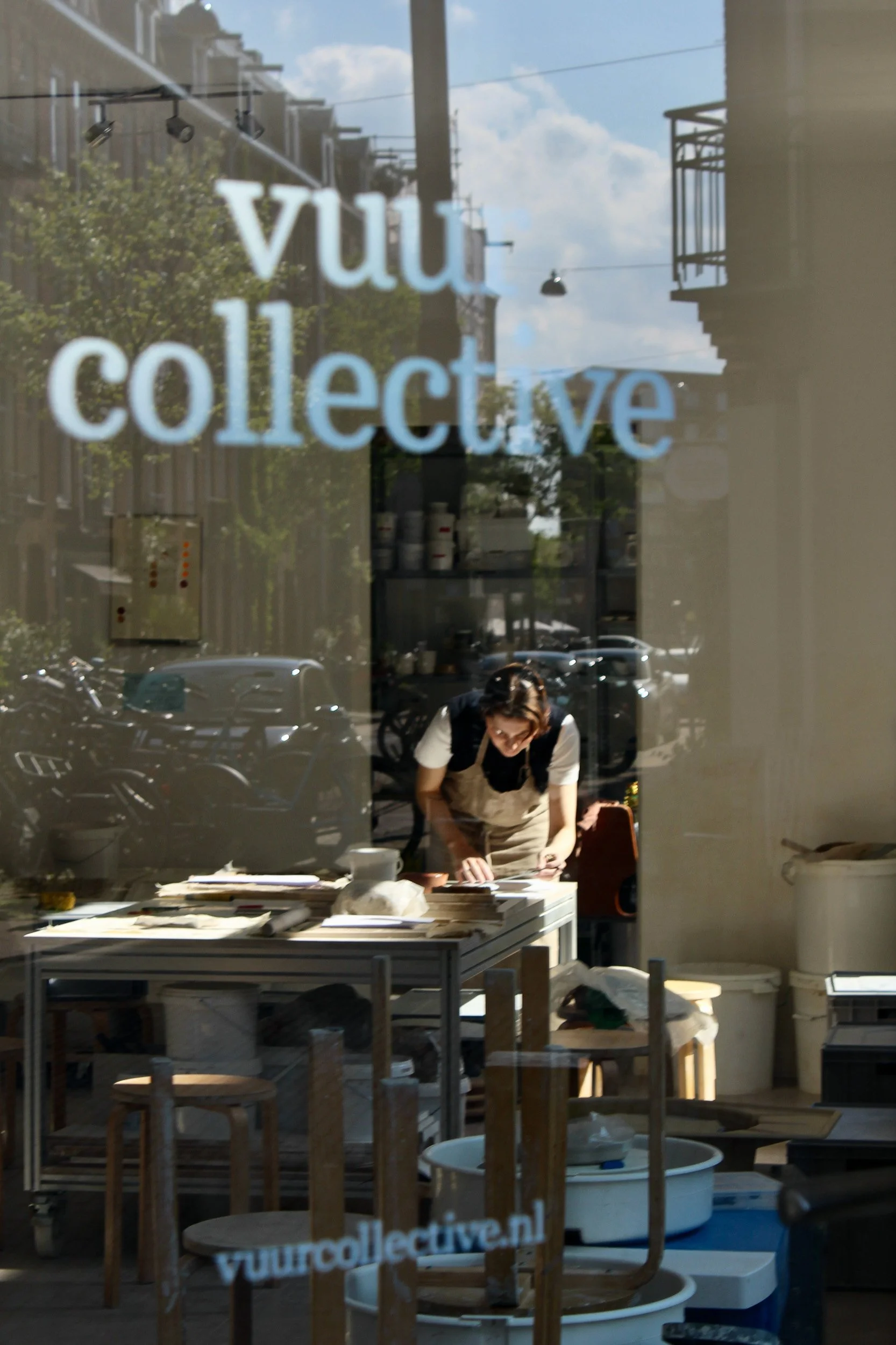 Vuur Collective studio interior with street reflection in the window, Amsterdam. Behind the scenes photography by Isabel Hachmann-Peralt.
