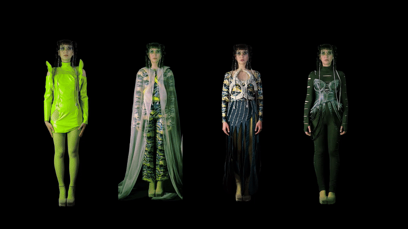 Four women standing in a row against a black background, each wearing futuristic fashion outfits with bold colors and patterns.