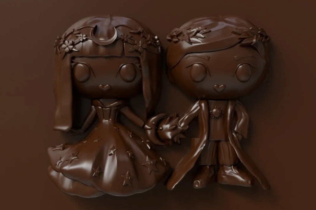 Chocolate sculpture of a girl and boy holding hands, with detailed clothing and hair, made entirely of milk or dark chocolate.