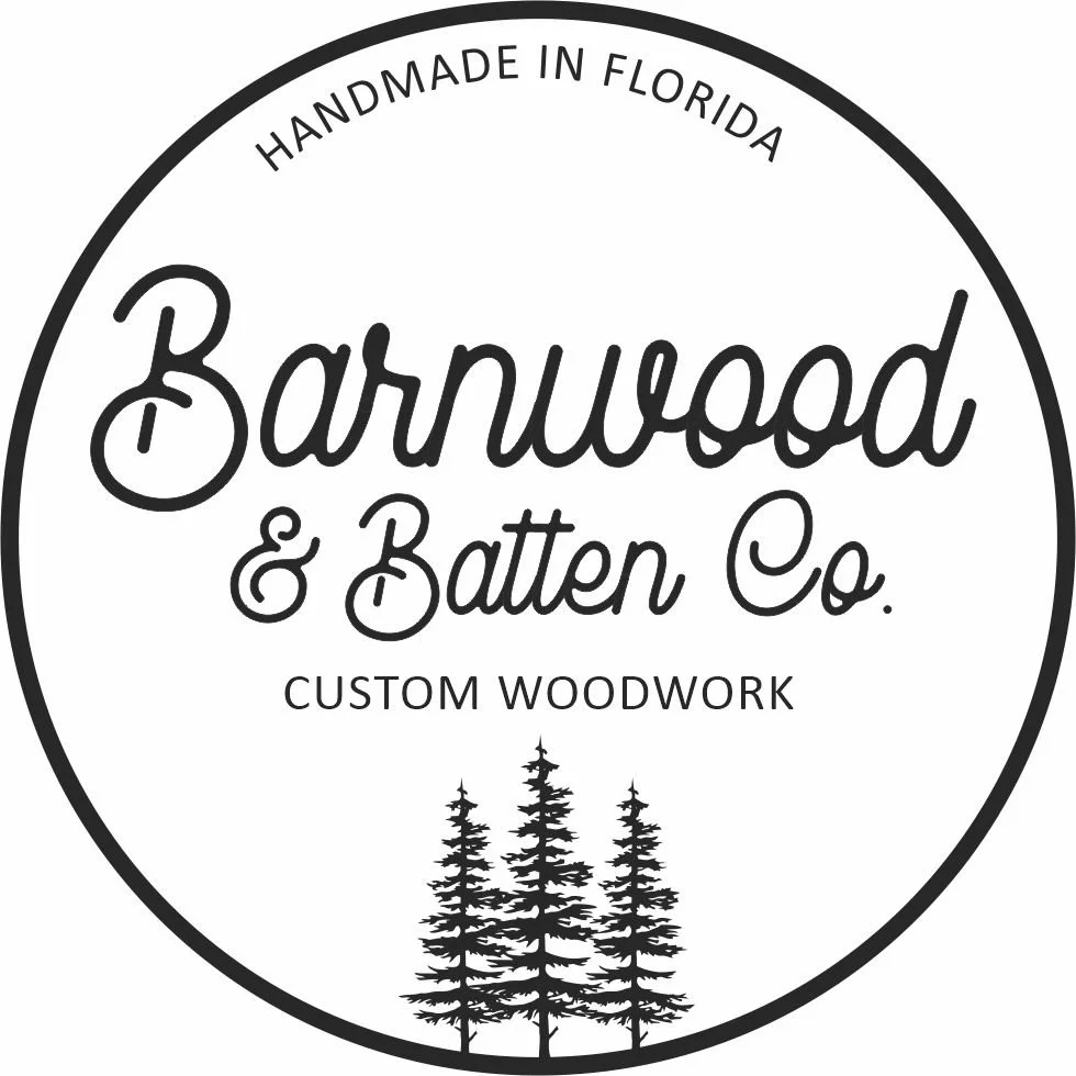 A circular black and white logo for Barnwood & Batten Co., a custom woodworking business made in Florida. The logo features the company name in decorative font, a subtitle indicating handmade in Florida, and a silhouette of three pine trees at the bo