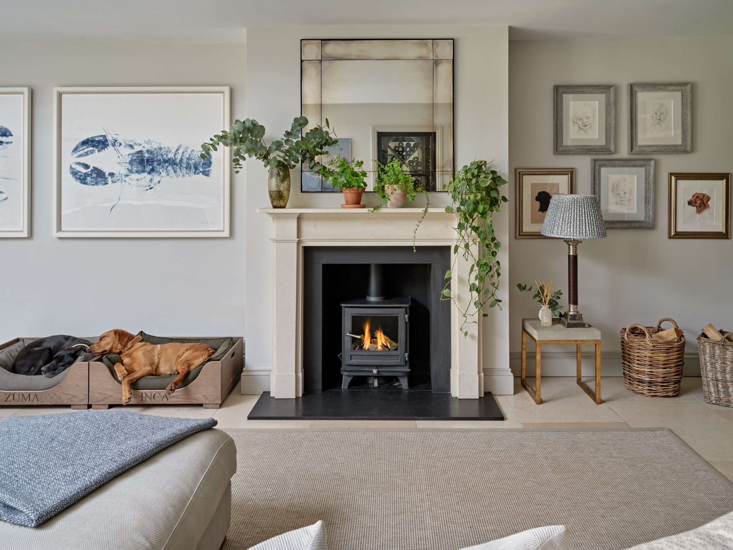 Living room with a fireplace, framed artwork, and a dog resting in a raised pet bed