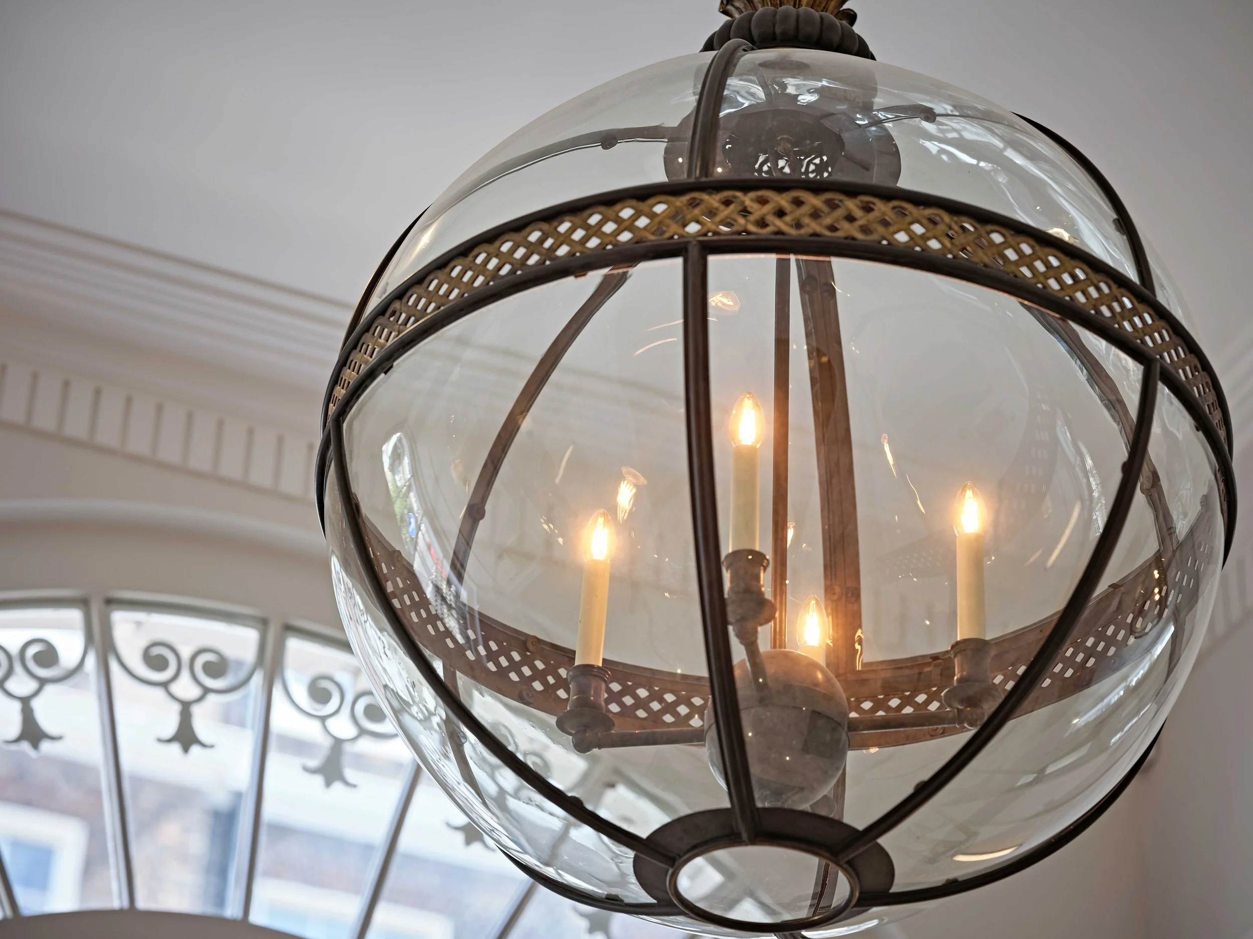 Close-up of a vintage style light fixture with a glass globe and Edison-style bulbs, hanging from the ceiling.